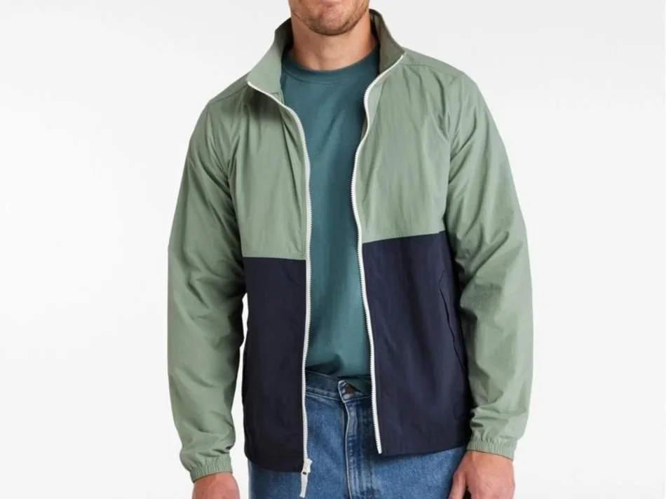 Man in a green and black winddbreaker unzipped