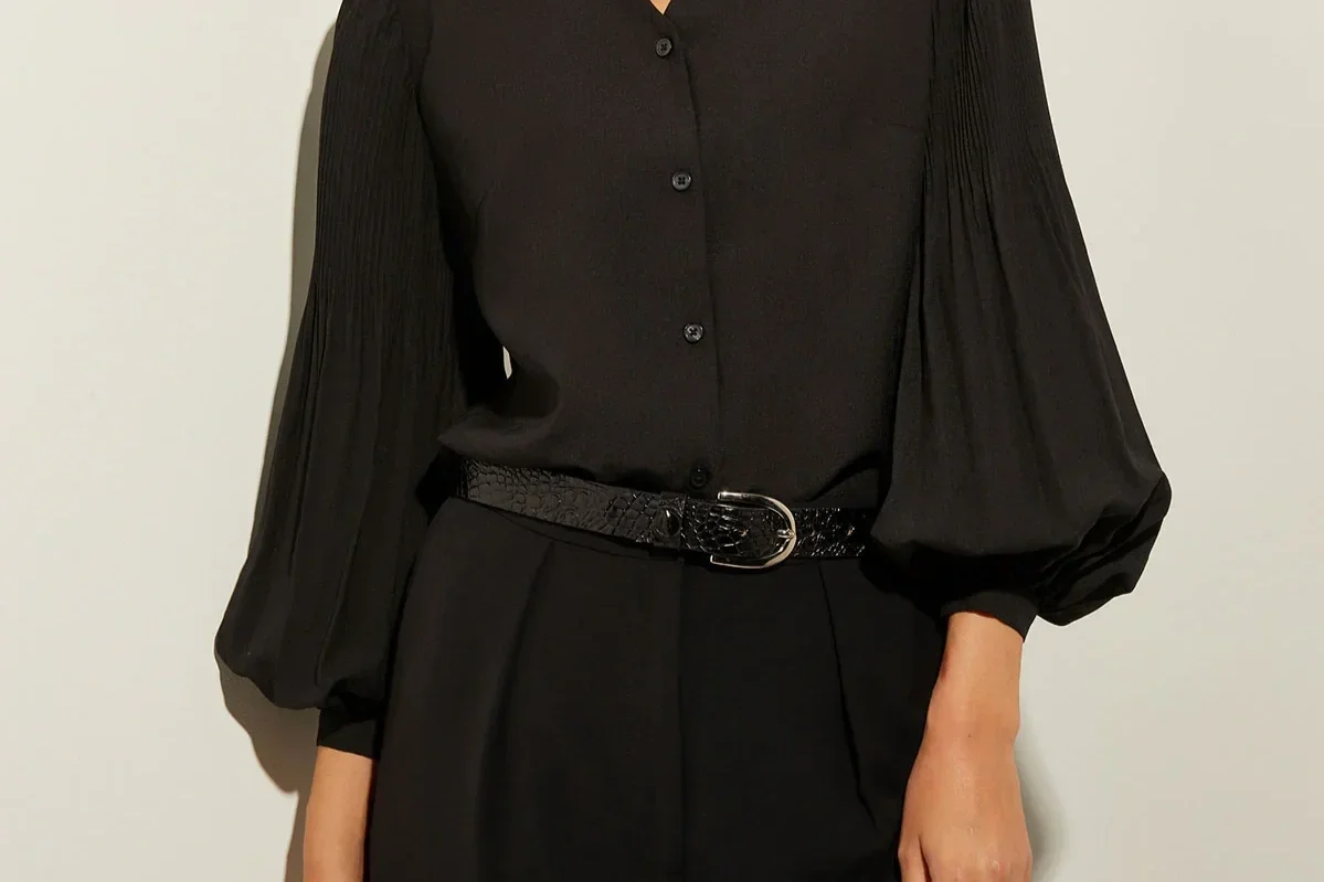 Woman in a black bishop sleeve top