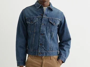 Man in a denim jacket with two chest pockets and diagonal pleats sewn in