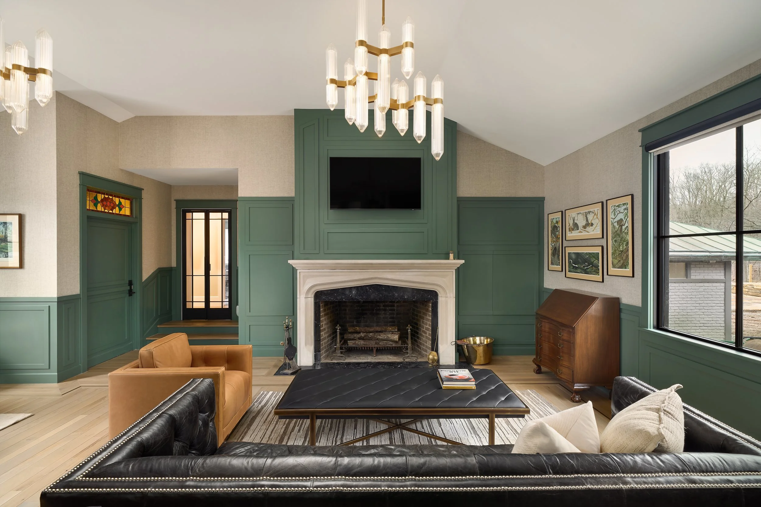 This custom Office and living room by Benham & Co Interior Design, a premier Columbus Ohio interior designer, showcases a sophisticated approach to luxury residential interior design in Westerville, Ohio. Featuring rich green paneled walls, a stateme