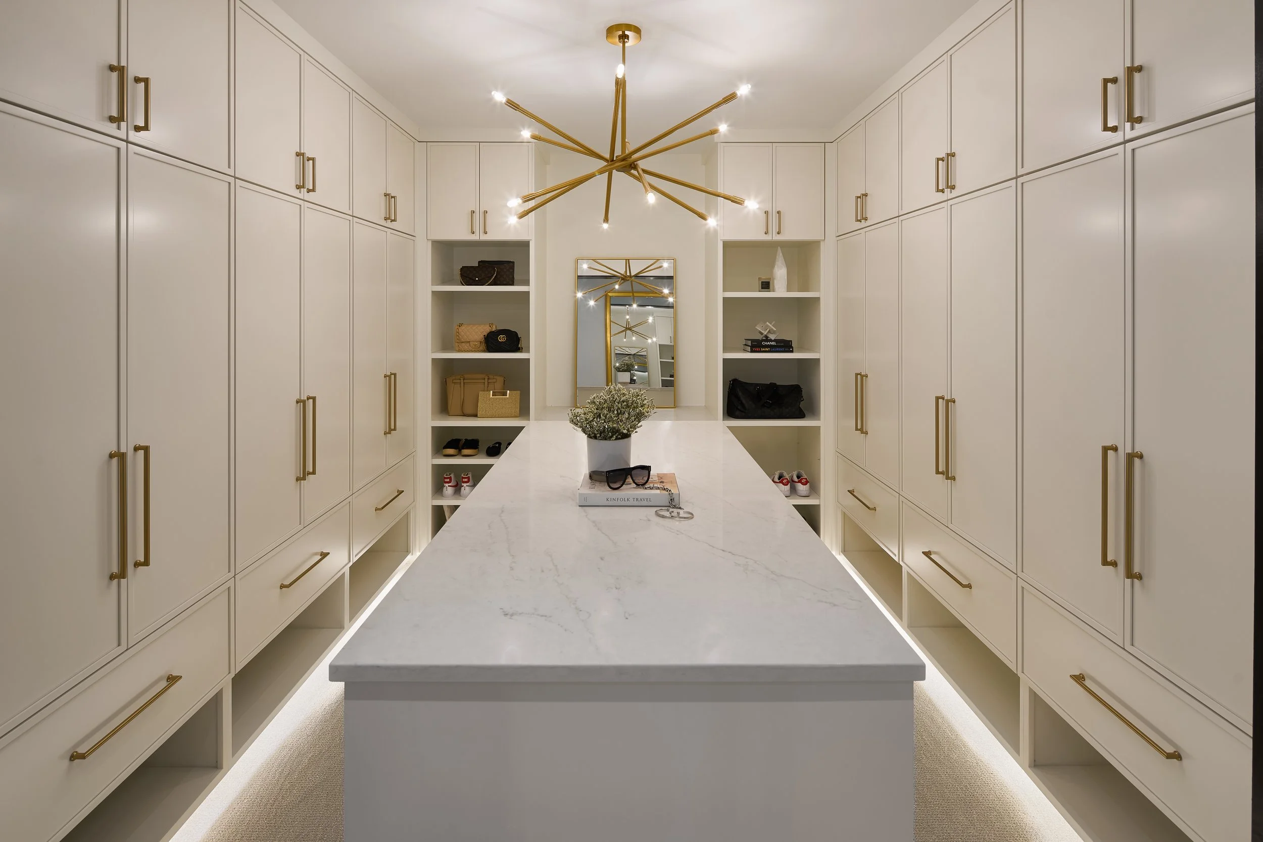 This custom walk-in closet in a luxury Bexley, Ohio full home remodel was designed by Benham & Co Interior Design, a premier Columbus Ohio interior design firm specializing in full-service residential design. Featuring floor-to-ceiling cabinetry, int