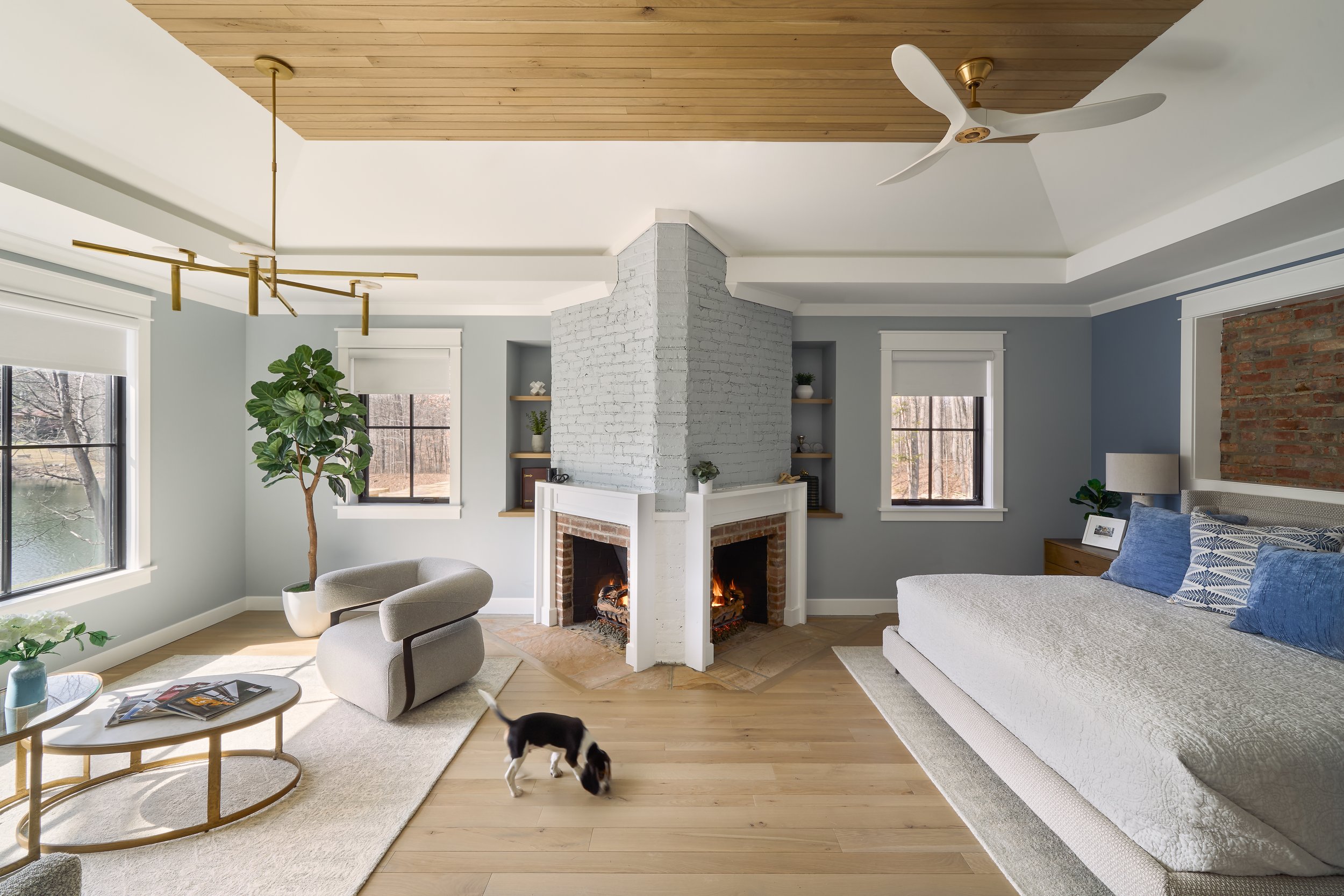 This custom bedroom retreat by Benham & Co Interior Design, a leading Columbus Ohio interior designer, showcases a refined approach to luxury residential interior design in Westerville, Ohio. Anchored by a dramatic double-sided fireplace with painted