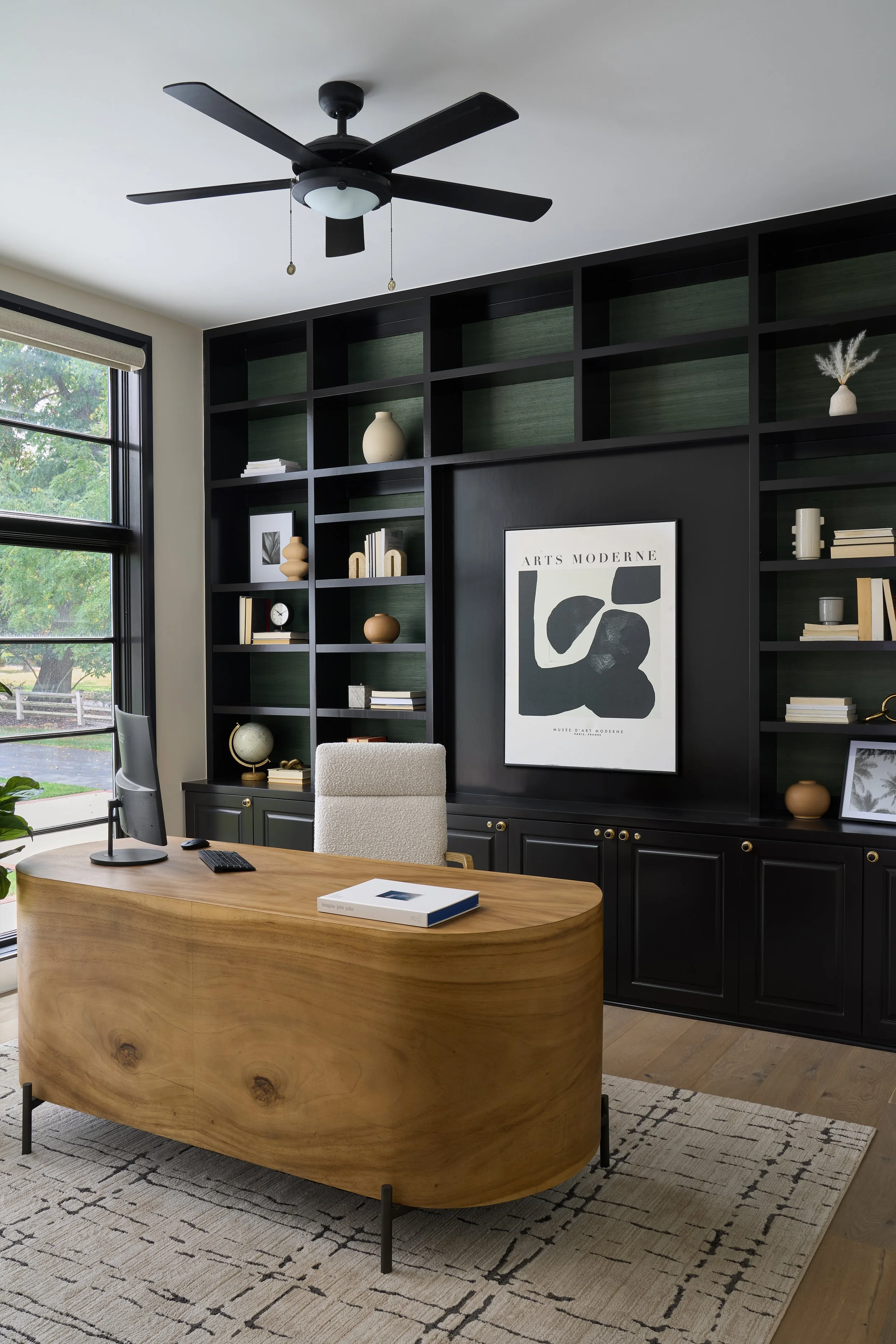 This custom home office in a luxury Bexley, Ohio full home remodel was designed by Benham & Co Interior Design, a premier Columbus Ohio interior design firm specializing in full-service residential design. Featuring a statement curved wood desk, floo