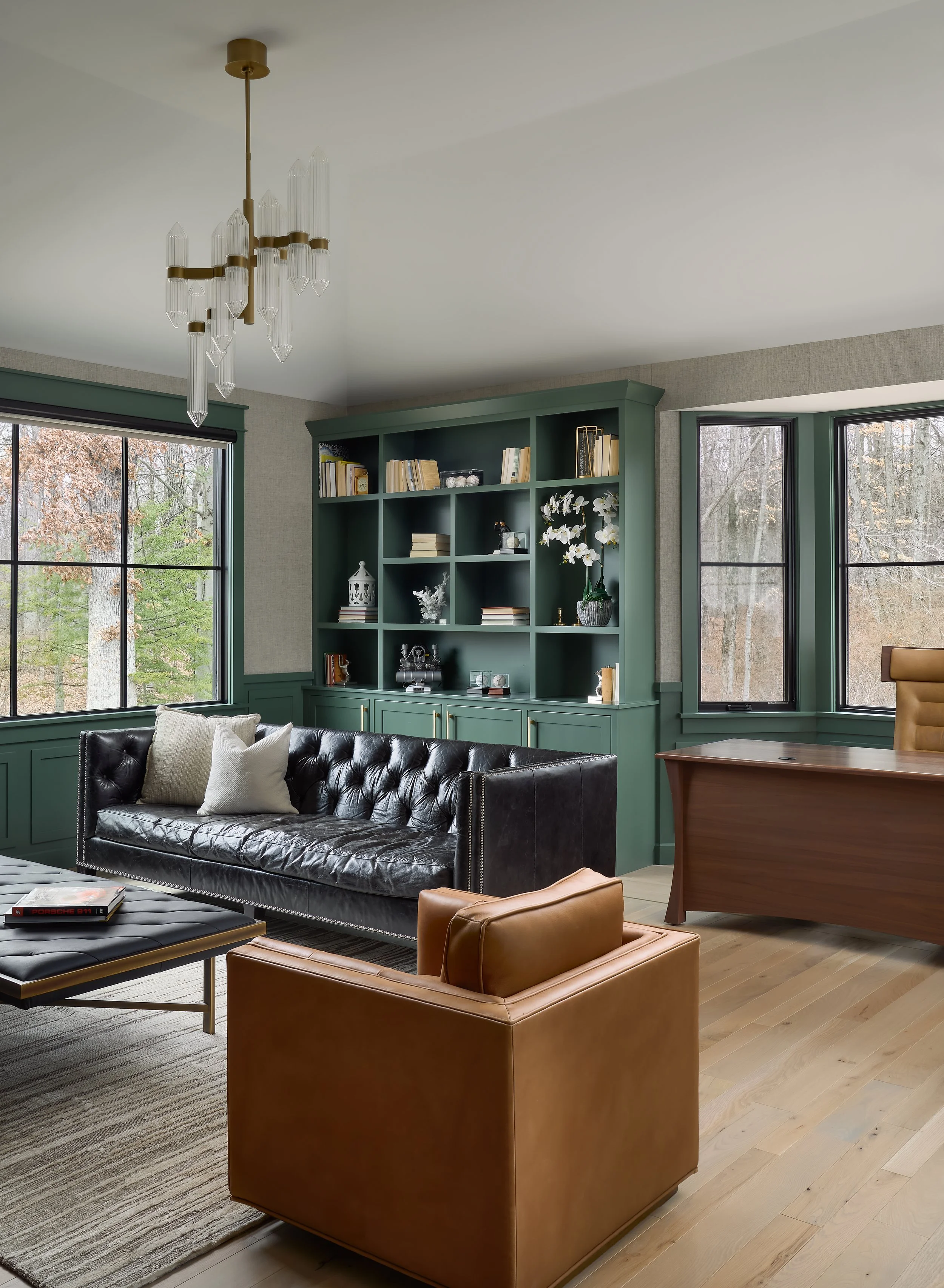 This custom home office and living space by Benham & Co Interior Design, a premier Columbus Ohio interior designer, showcases a sophisticated approach to luxury residential interior design in Westerville, Ohio. Rich green built-in cabinetry creates a