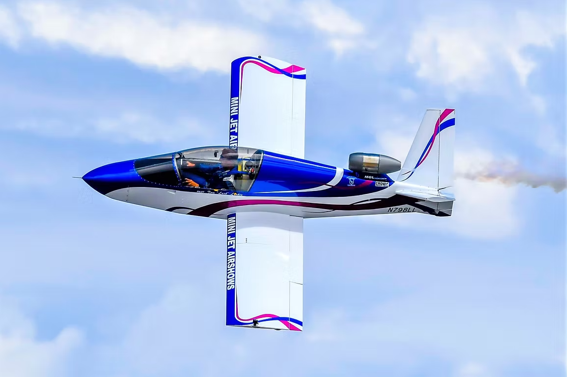 A blue and white jet aircraft performing a vertical maneuver with wings above and below.