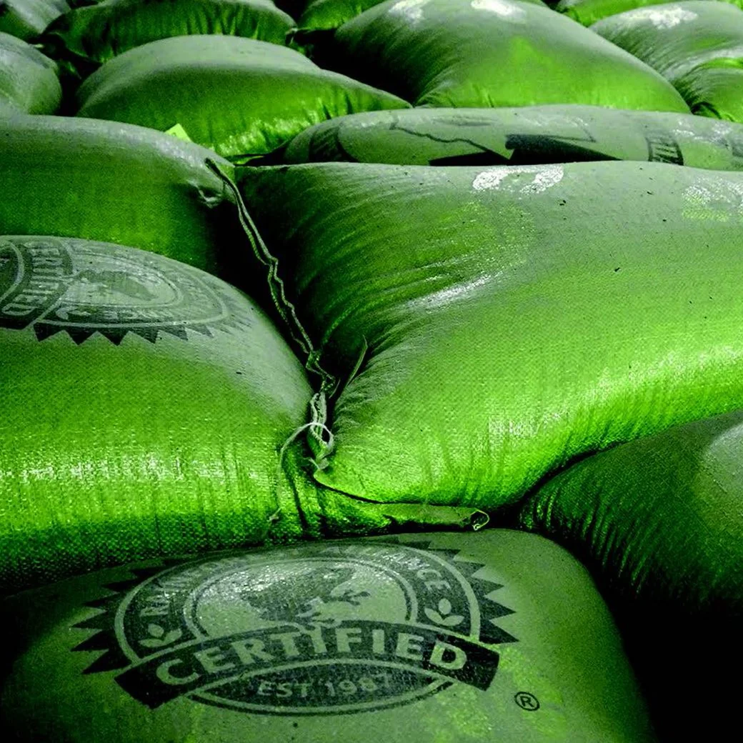 Stacks of certified coffee bean bags ready for transport, highlighting responsible sourcing, quality assurance, and sustainable supply chain practices from farm to cup..jpg