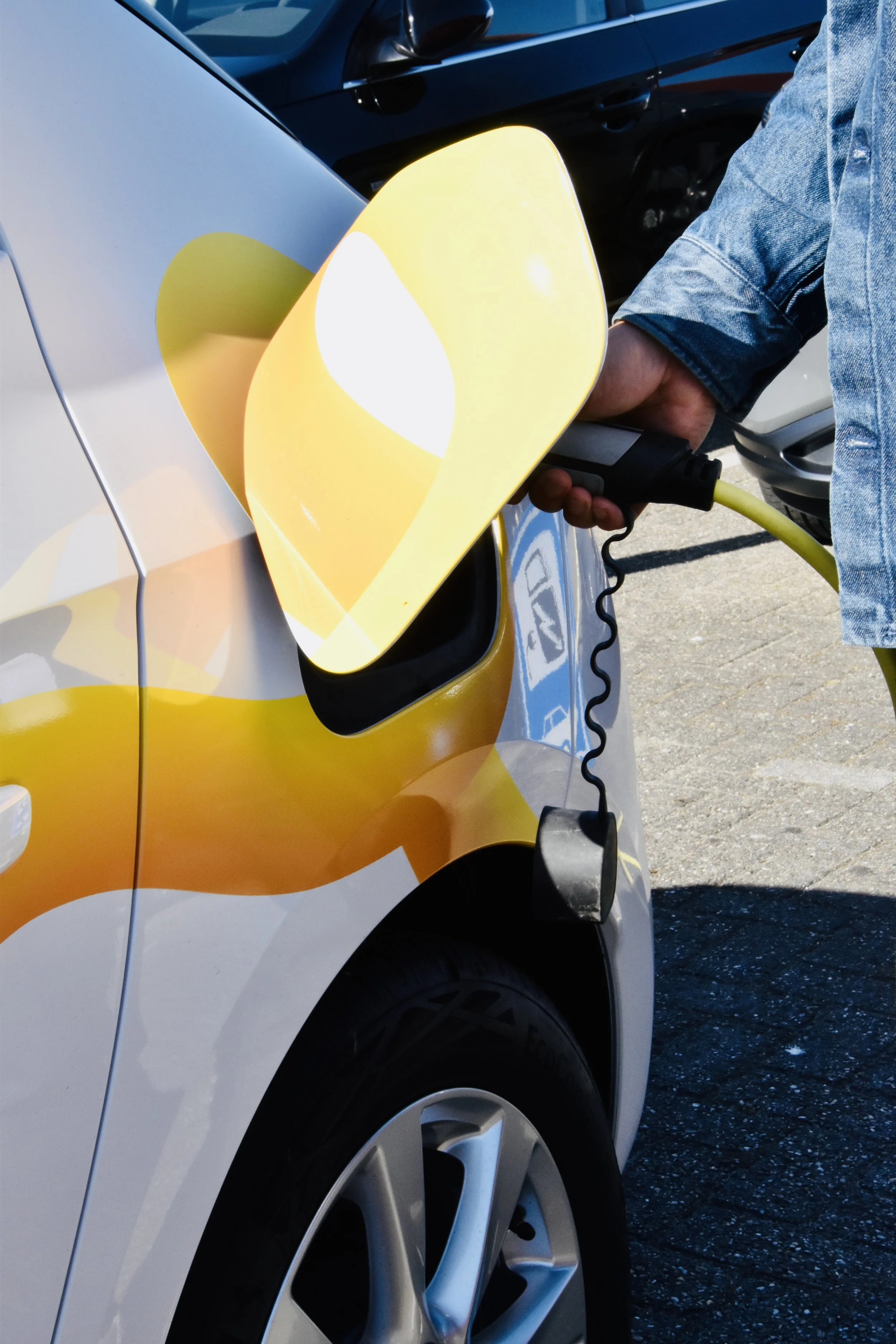 Close-up of an electric vehicle charging at a public charging station, highlighting sustainable mobility, clean energy technology, and the transition to greener transportation..jpg