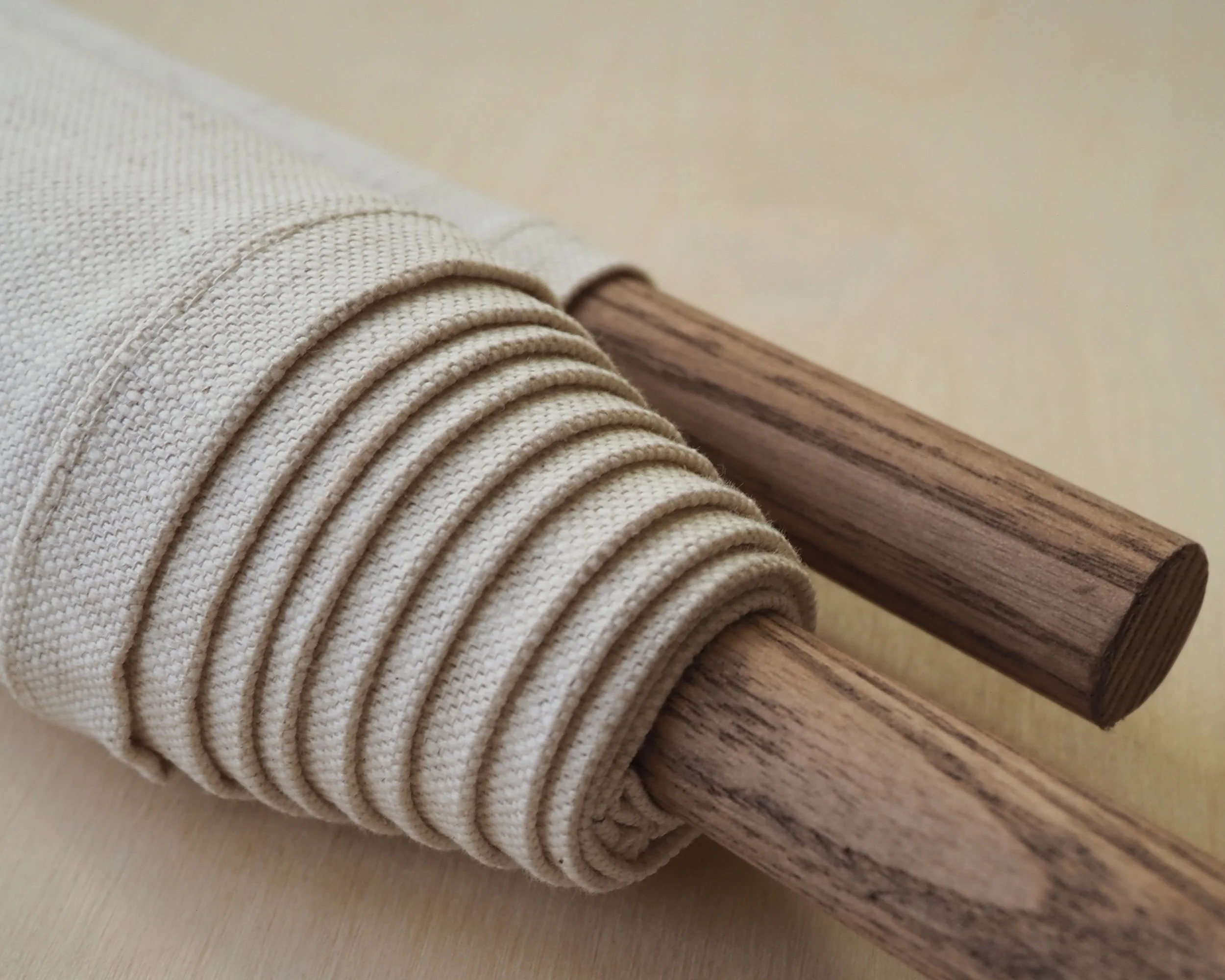 Close up of wall hanging rolled up around wood pole