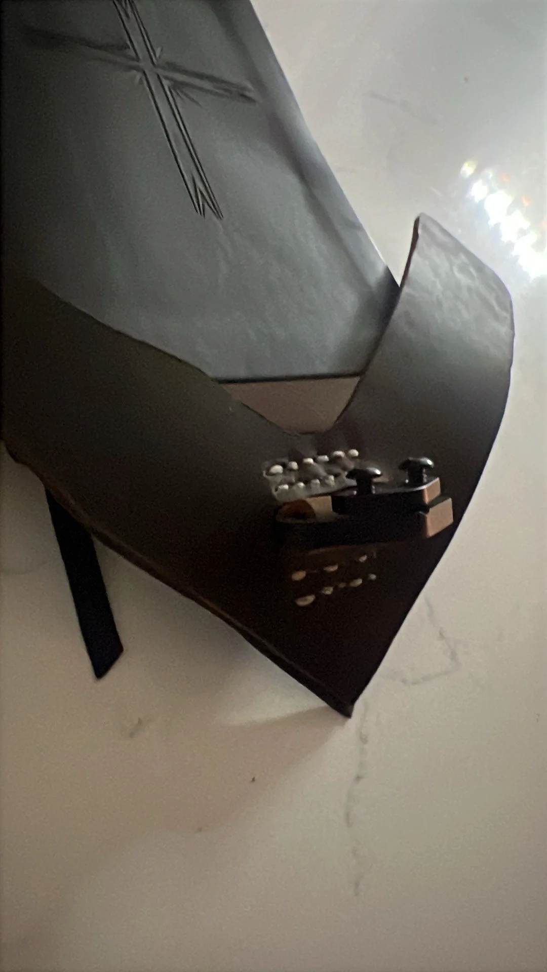Close-up of a black tabletop arcade game console with joysticks and buttons, on a white marble surface.