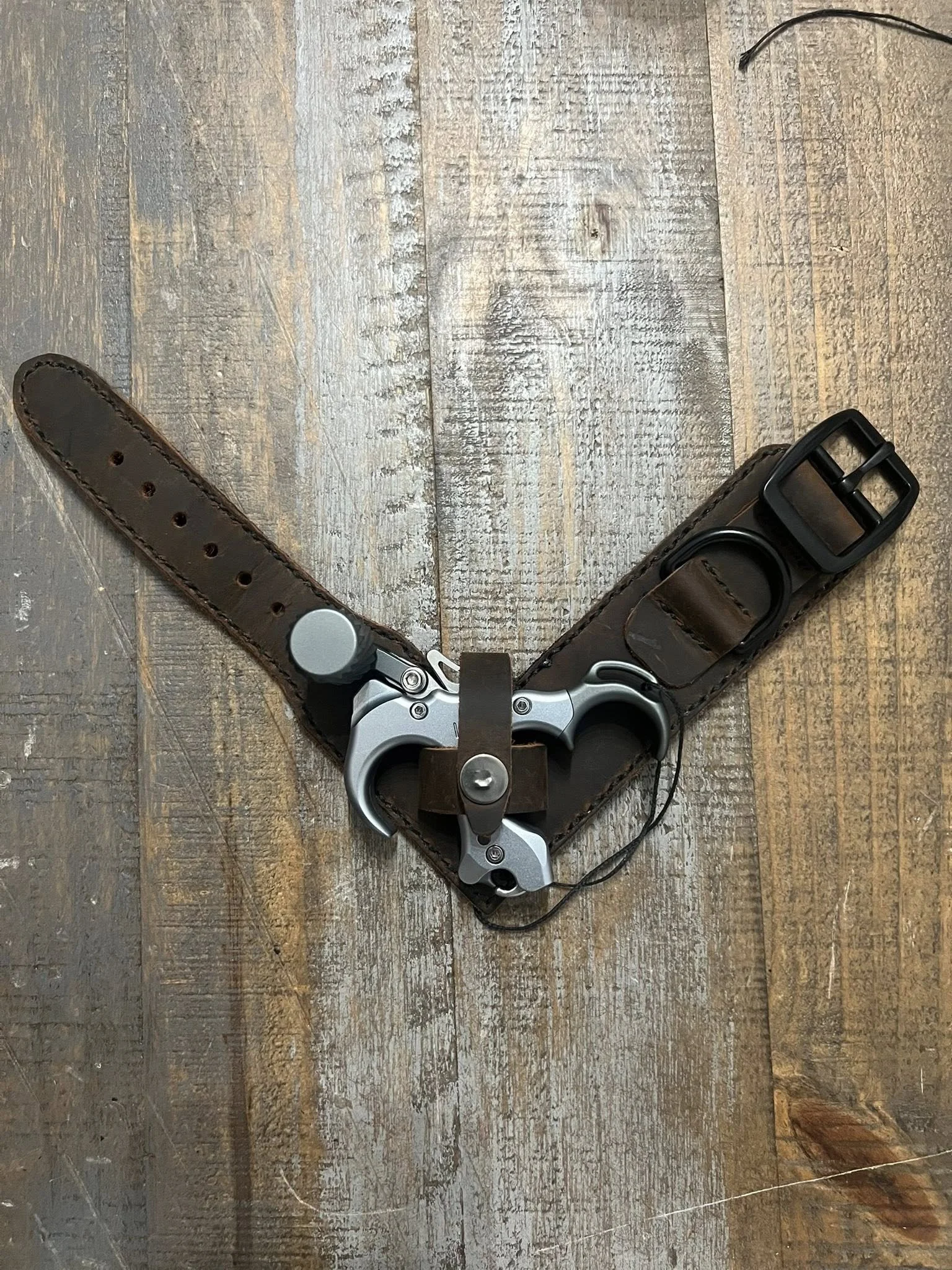 Custom archery release strap with brown leather and hand stitching.