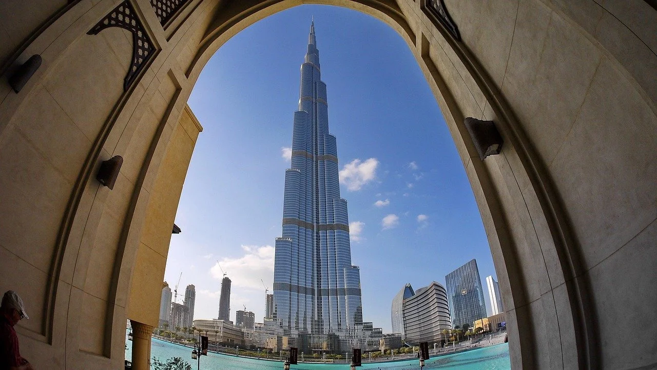 The Burj Khalifa skyscraper in Dubai, viewed from beneath an archway.