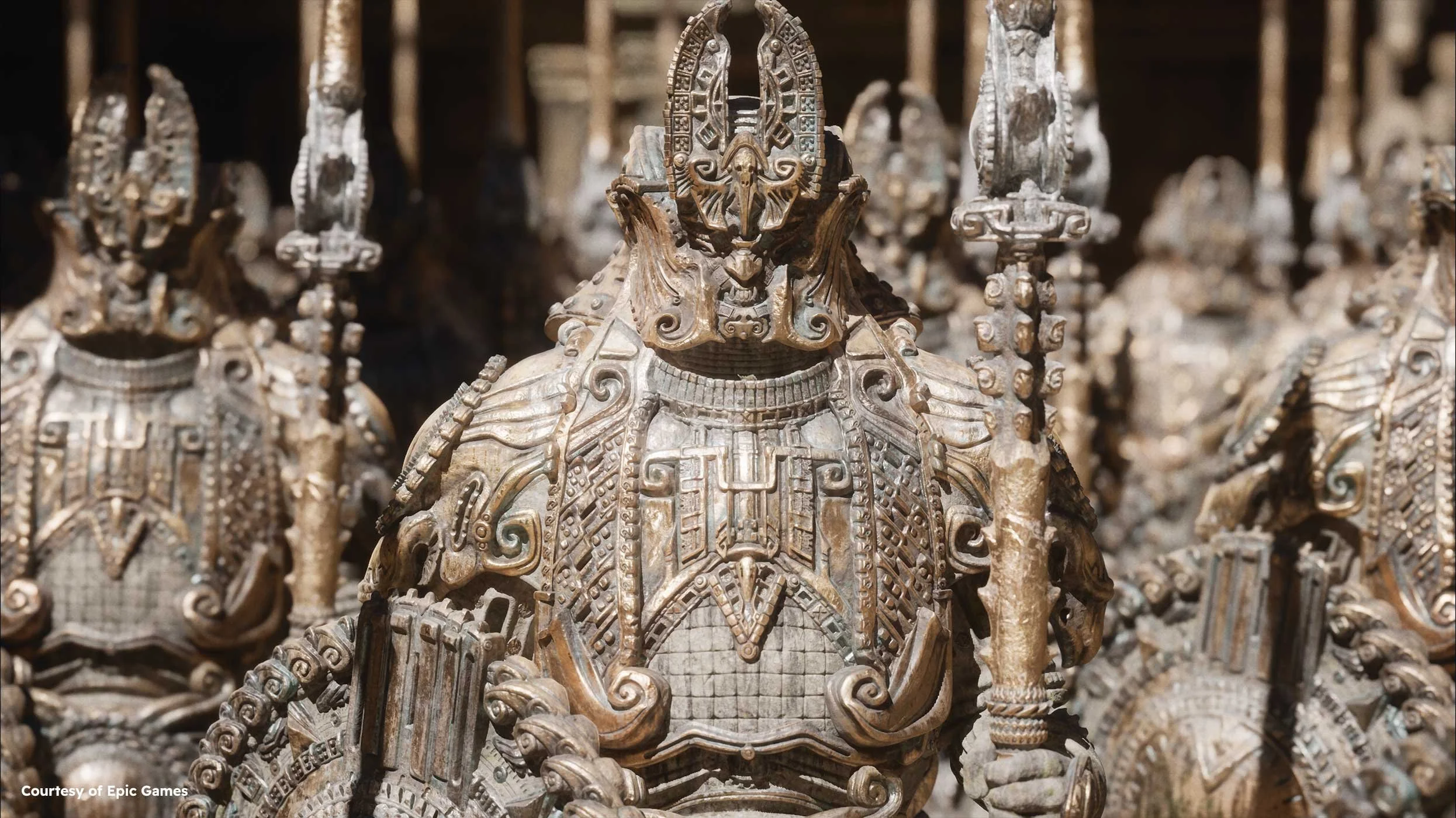A detailed close-up of intricately designed gold and silver armored statues, likely representing warriors, with elaborate decorative elements and facial masks.