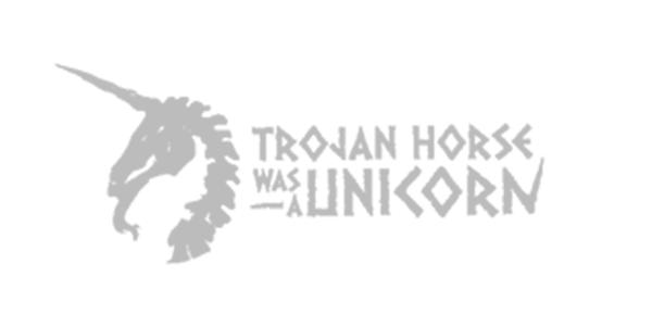 A gray unicorn head silhouette with a flowing mane next to the text 'TROJAN HORSE AND JUNK CORN' in gray on a black background.