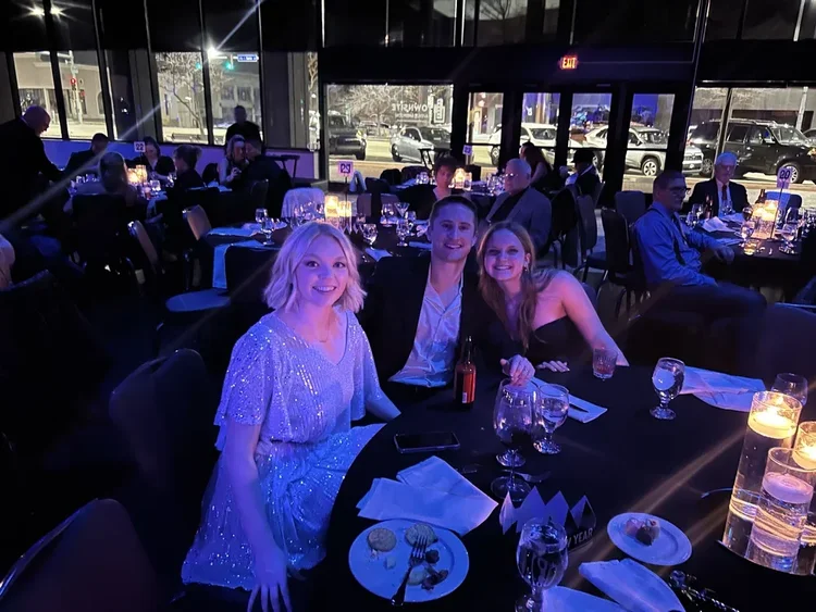 Guests at a formal dinner in a dimly lit restaurant.