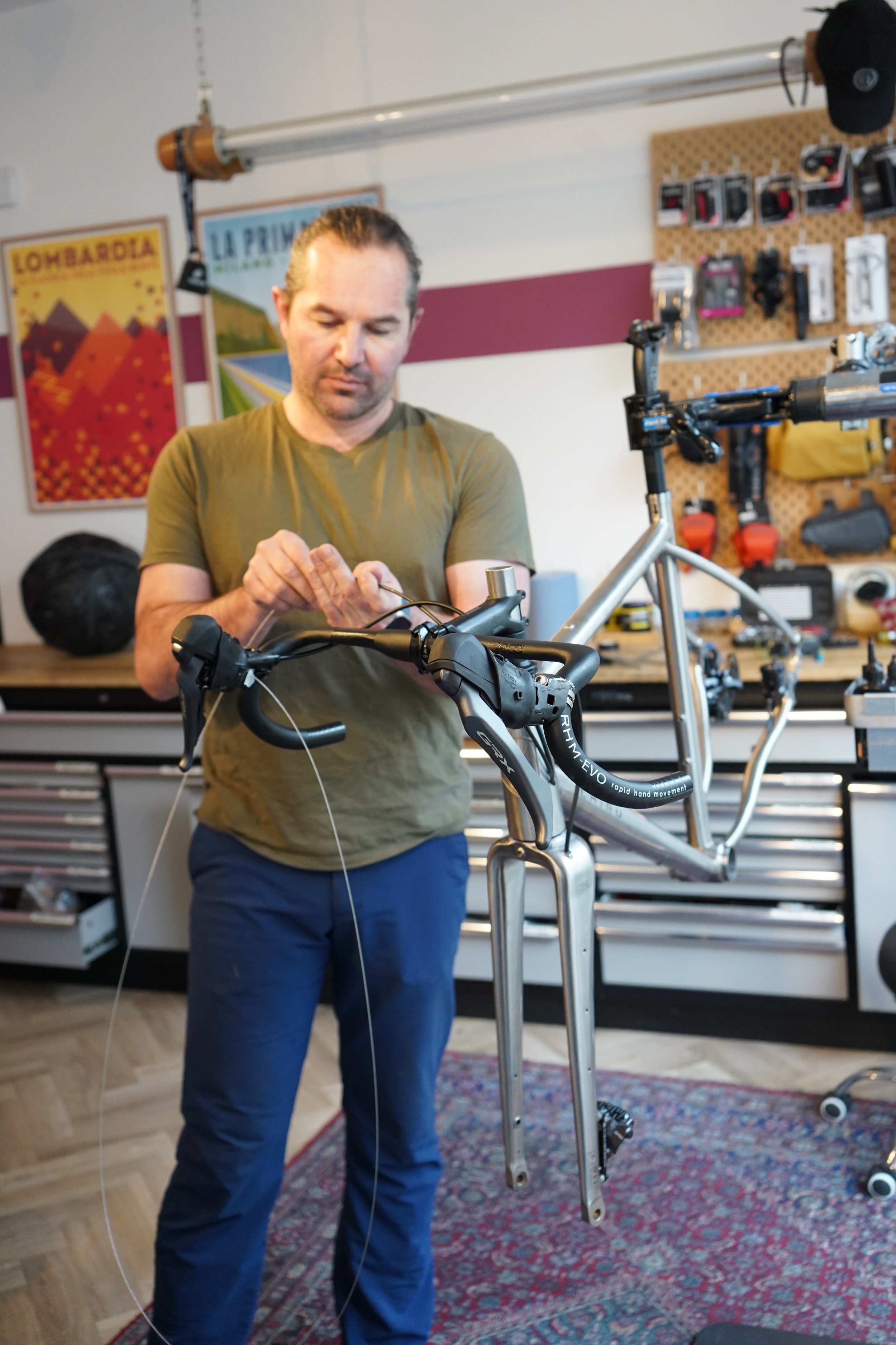 A man working on assembling a bicycle frame in a workshop.