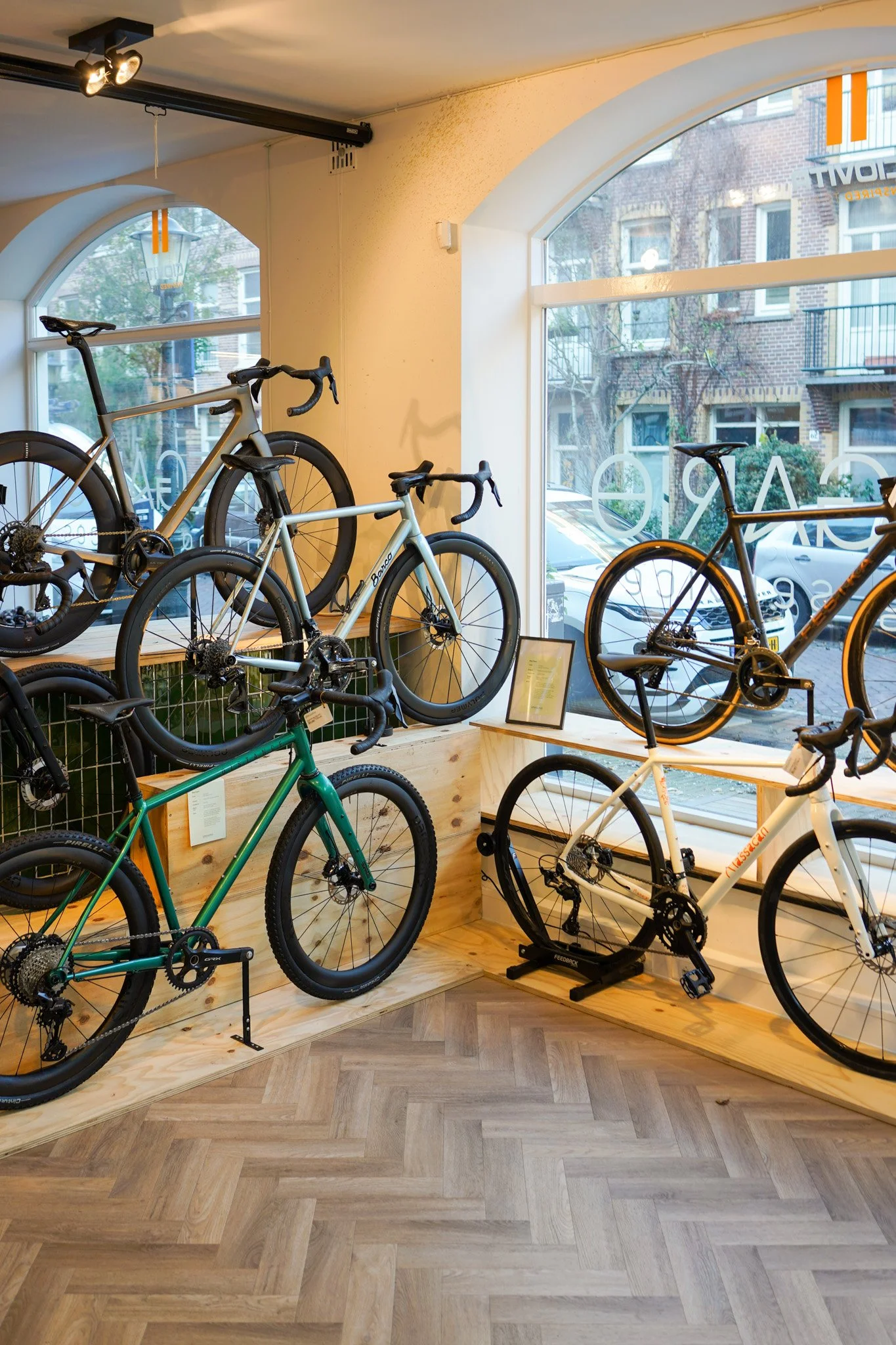 Indoor bicycle shop with bicycles on display near large windows.