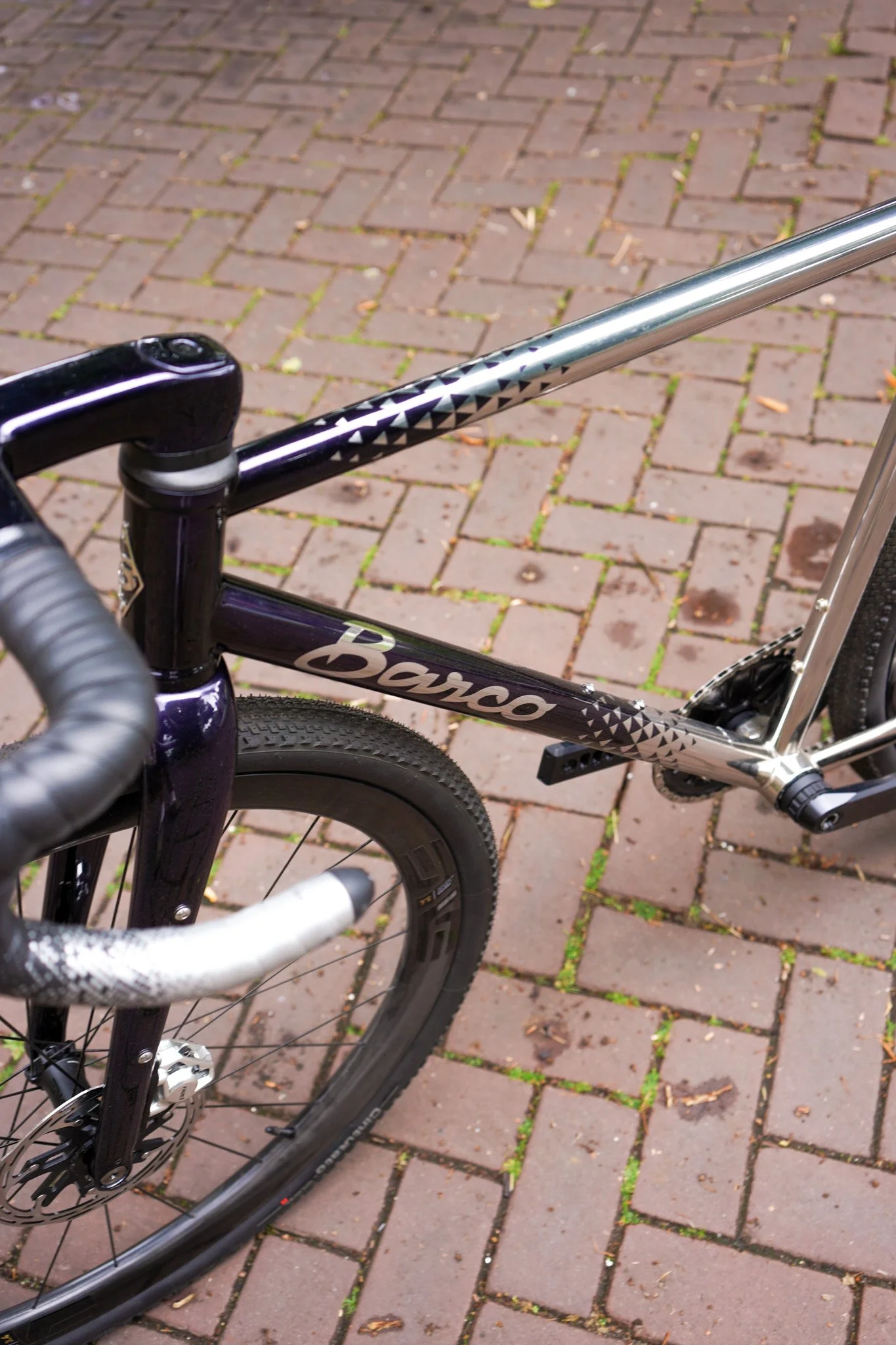 A black and silver bicycle with the brand name 'Basso' on the frame, positioned on a brick-paved surface.