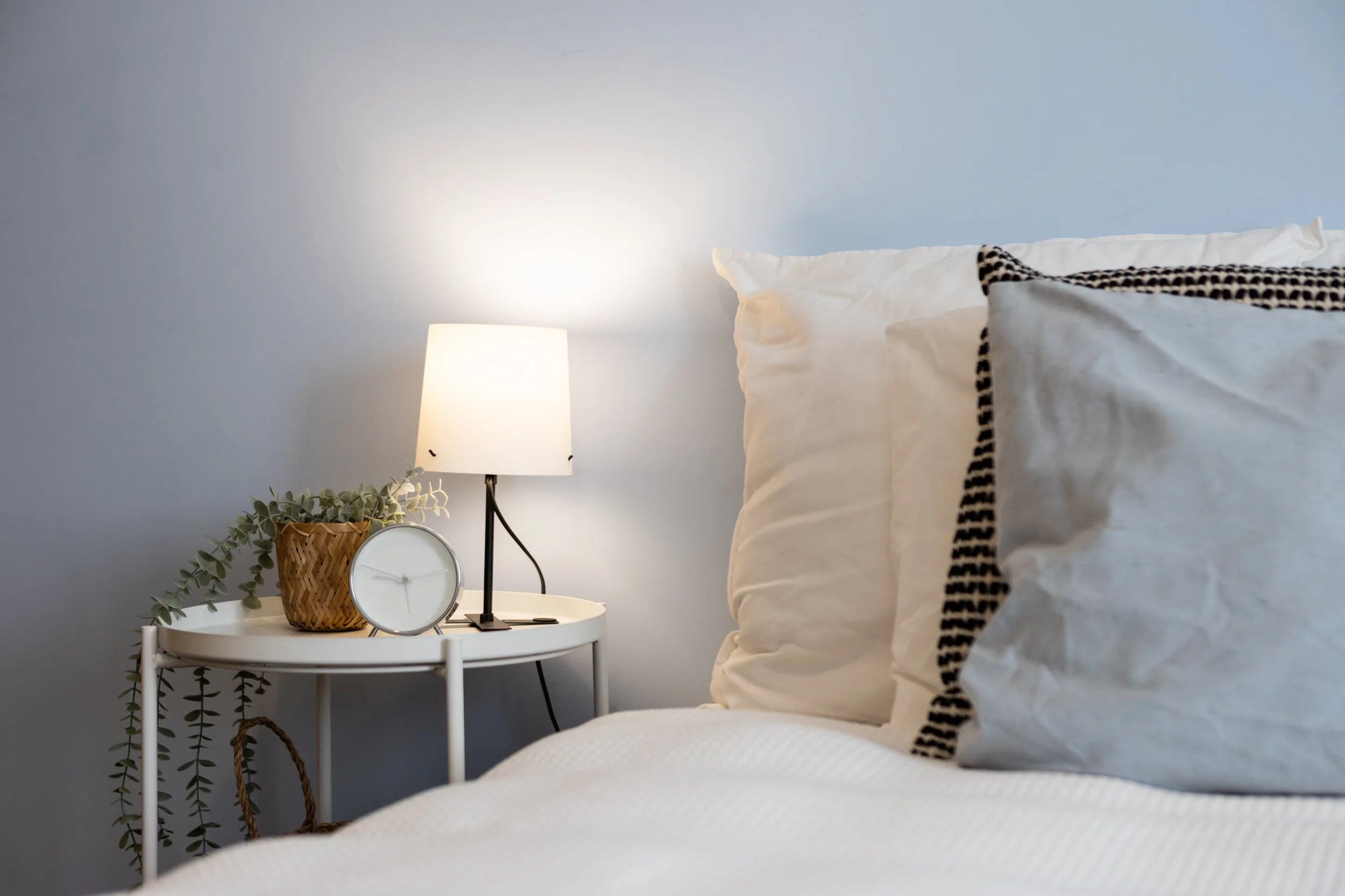 detalhe de quarto de apartamento t3 parque das nações com parede azul clara e homestaging moderno com têxteis neutros