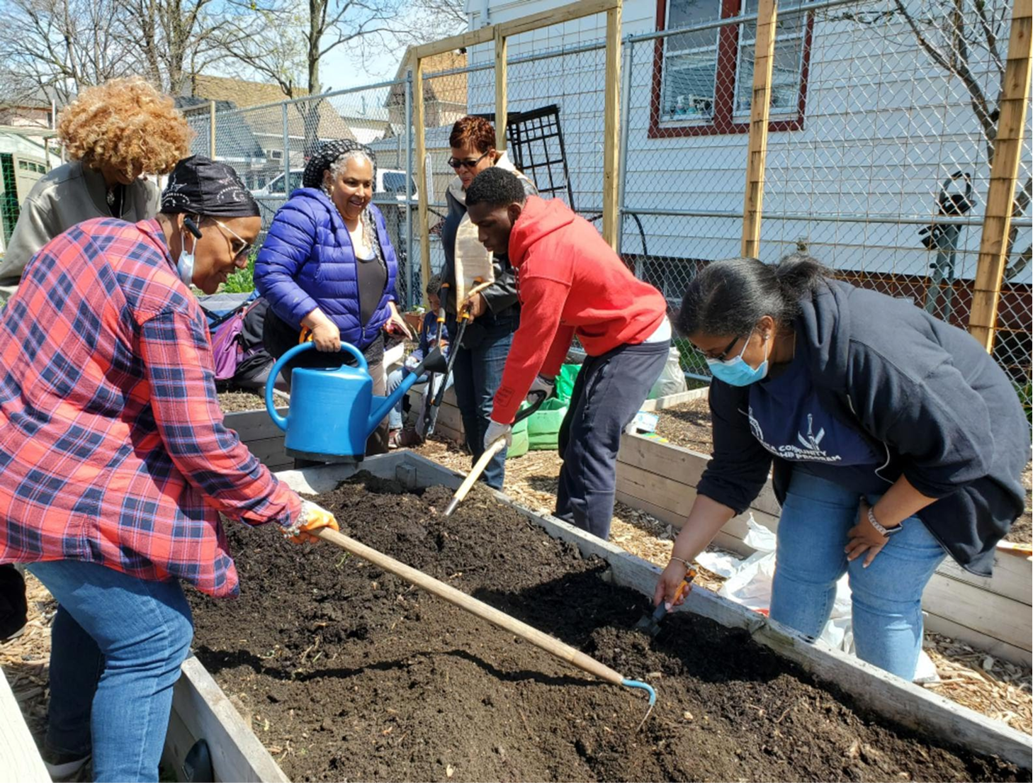 Group of diverse people planting trees in a community garden