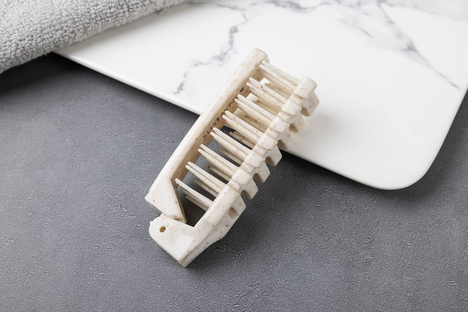 環境配慮素材 折りたたみコーム（アイボリー系／粒入り）
折りたたみ時 約9.5cm、展開時 約18cm。携帯しやすい折りたたみ仕様で、ホテルアメニティに適しています。お客様のご要望に合わせて印刷（名入れ・ロゴ）対応可能です