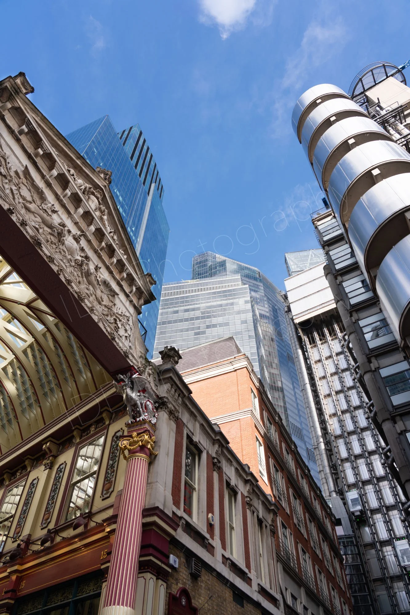 Old meets new. A view from the ground looking upwards featuring Leadenhall Market, The Lloyds Building and modern glass skyscrapers.