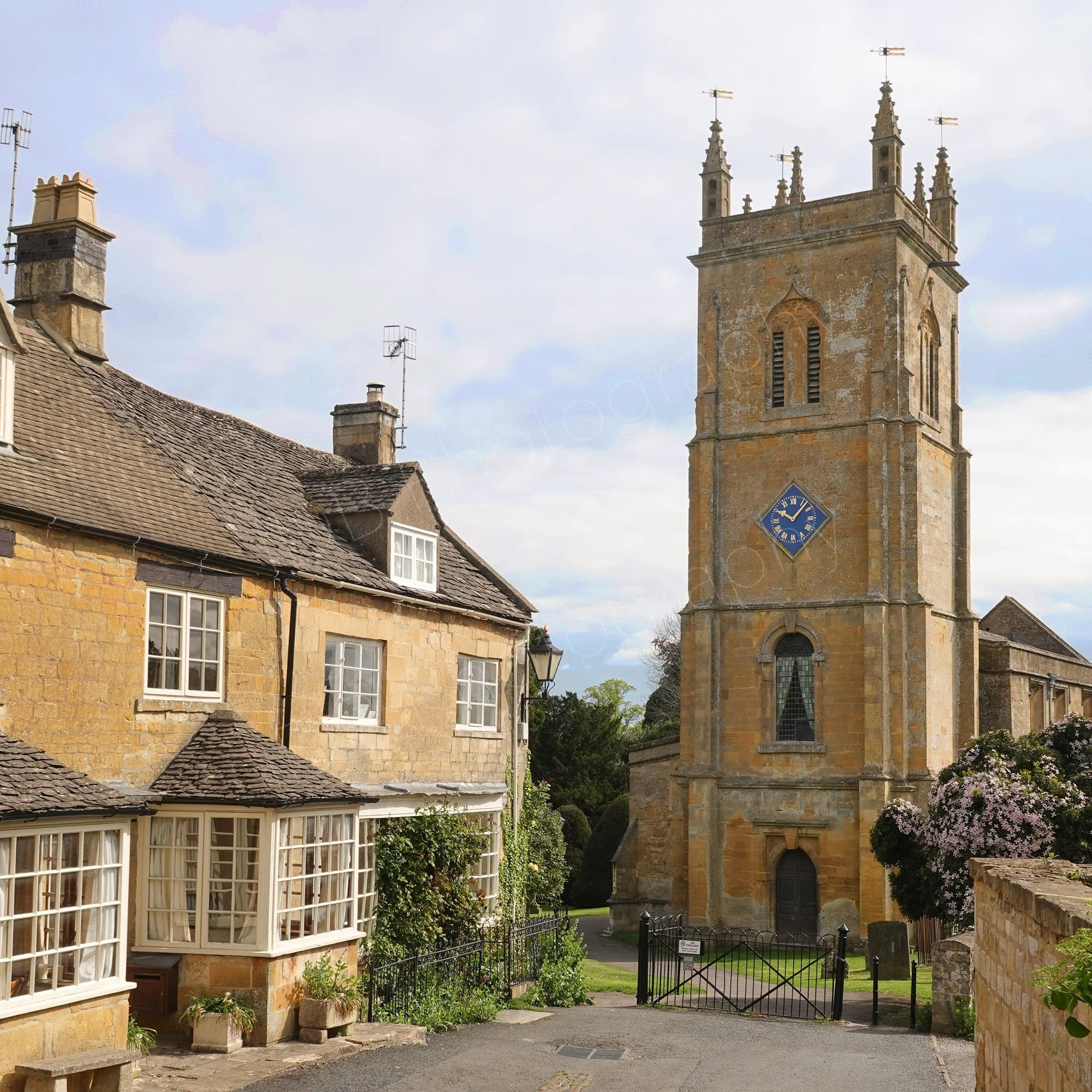 The Church of St Peter and St Paul and honey-coloured stone cottages in the Cotswold village of Blockley, Gloucestershire, the setting of "Father Brown".
