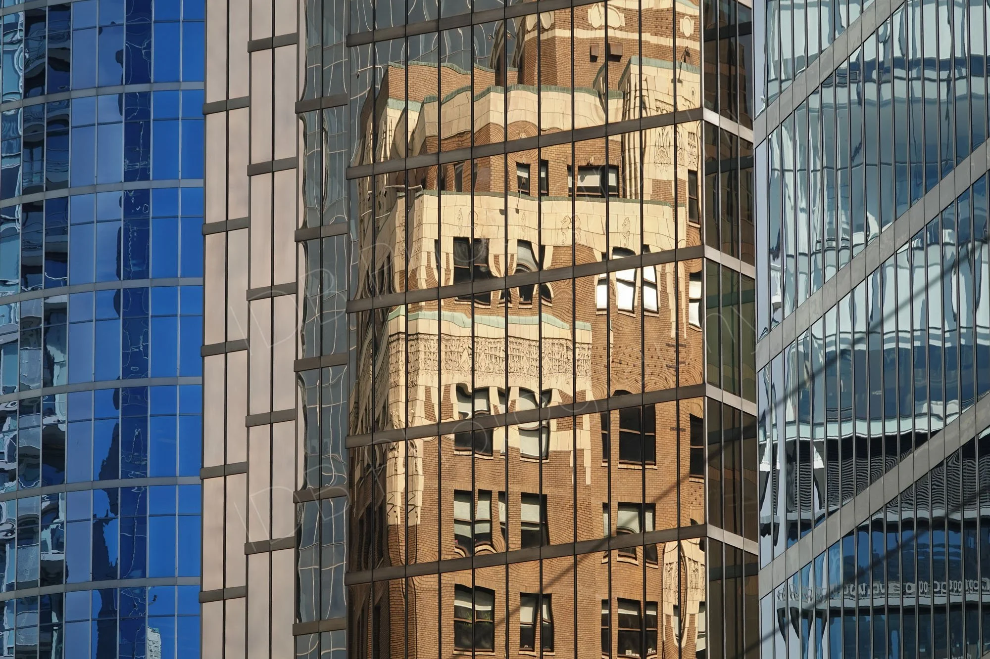 A picture of lines. Close up of a group of adjacent buildings with a mix of perpendicular and other lines and a reflection. Vancouver, BC.