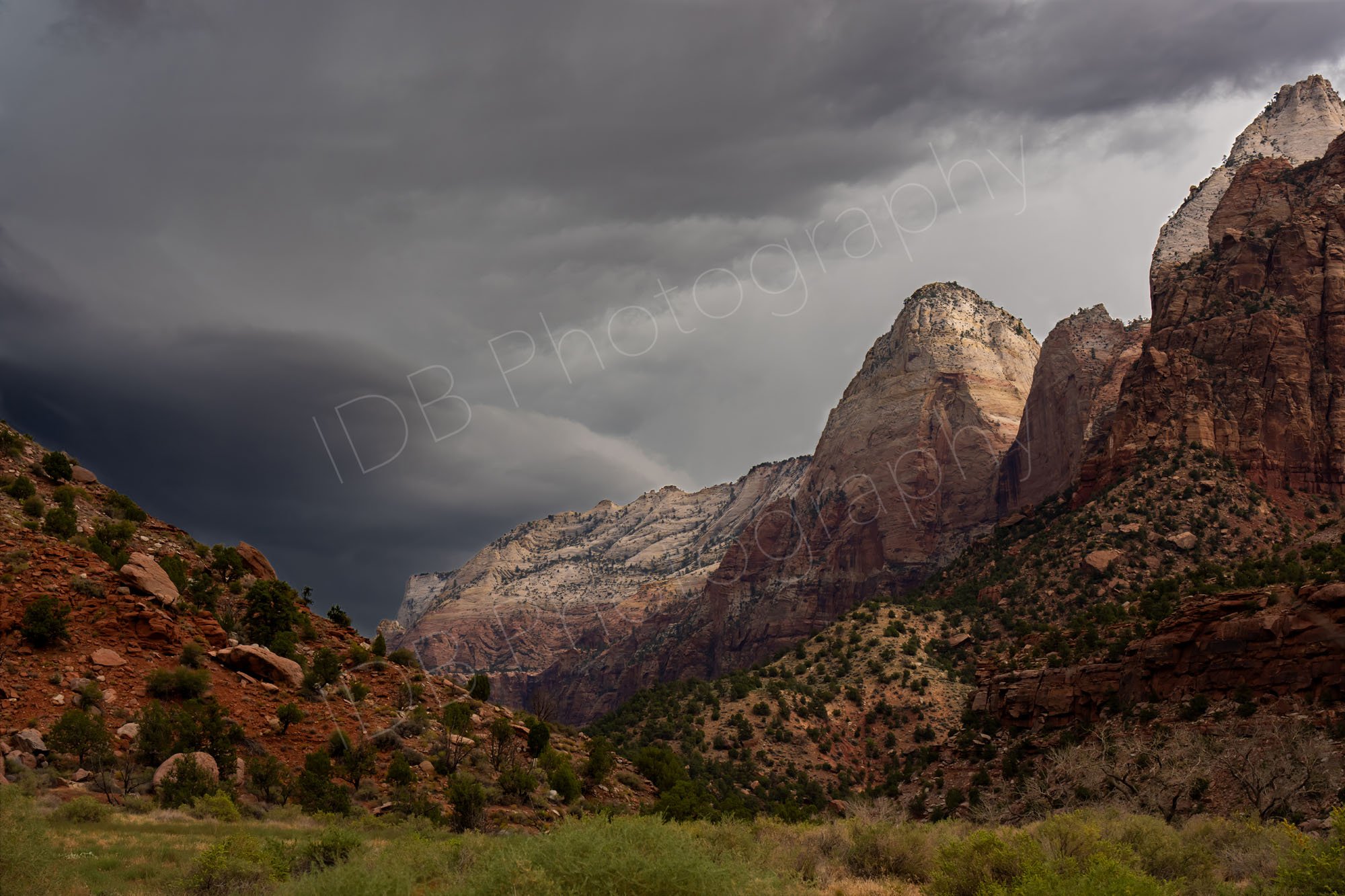 Dramatic, stormy sky over the towering sandstone cliffs and rugged landscape of Zion National Park in Utah.