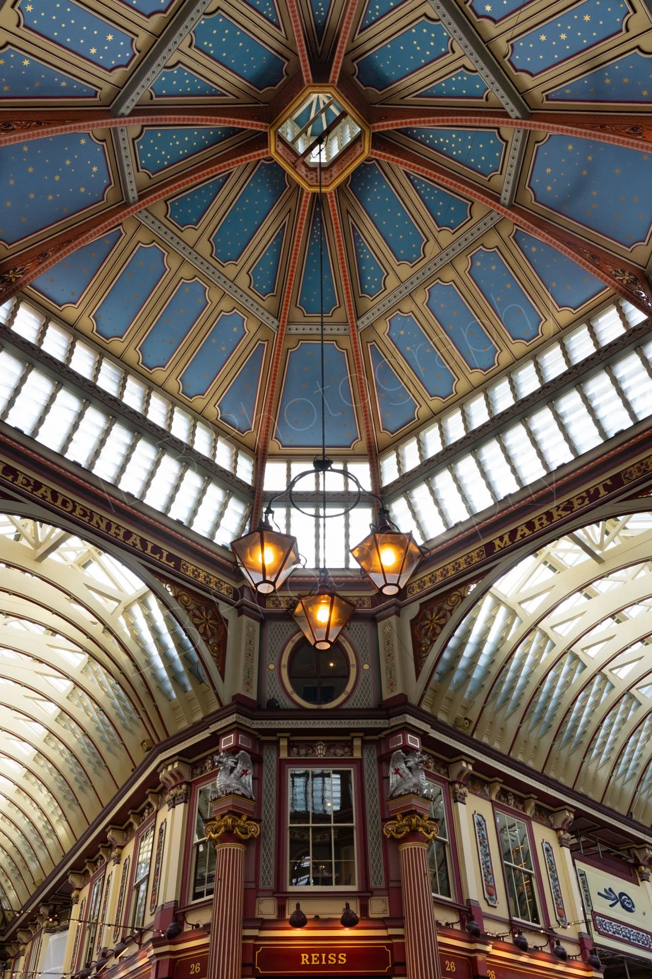 Inside Leadenhall Market with it's ornate blue ceiling and vaulted glass ceilinged walkways.
Two walkways ceilings are seen going off tangentially.