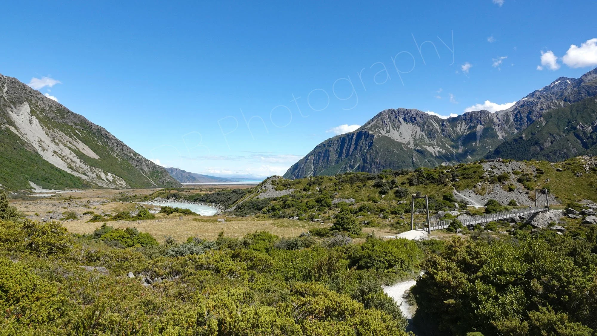 View of river with  bridge, mountains, sky and view towards Lake Pukaki on the Hooker Valley track,  Canterbury, New Zealand.