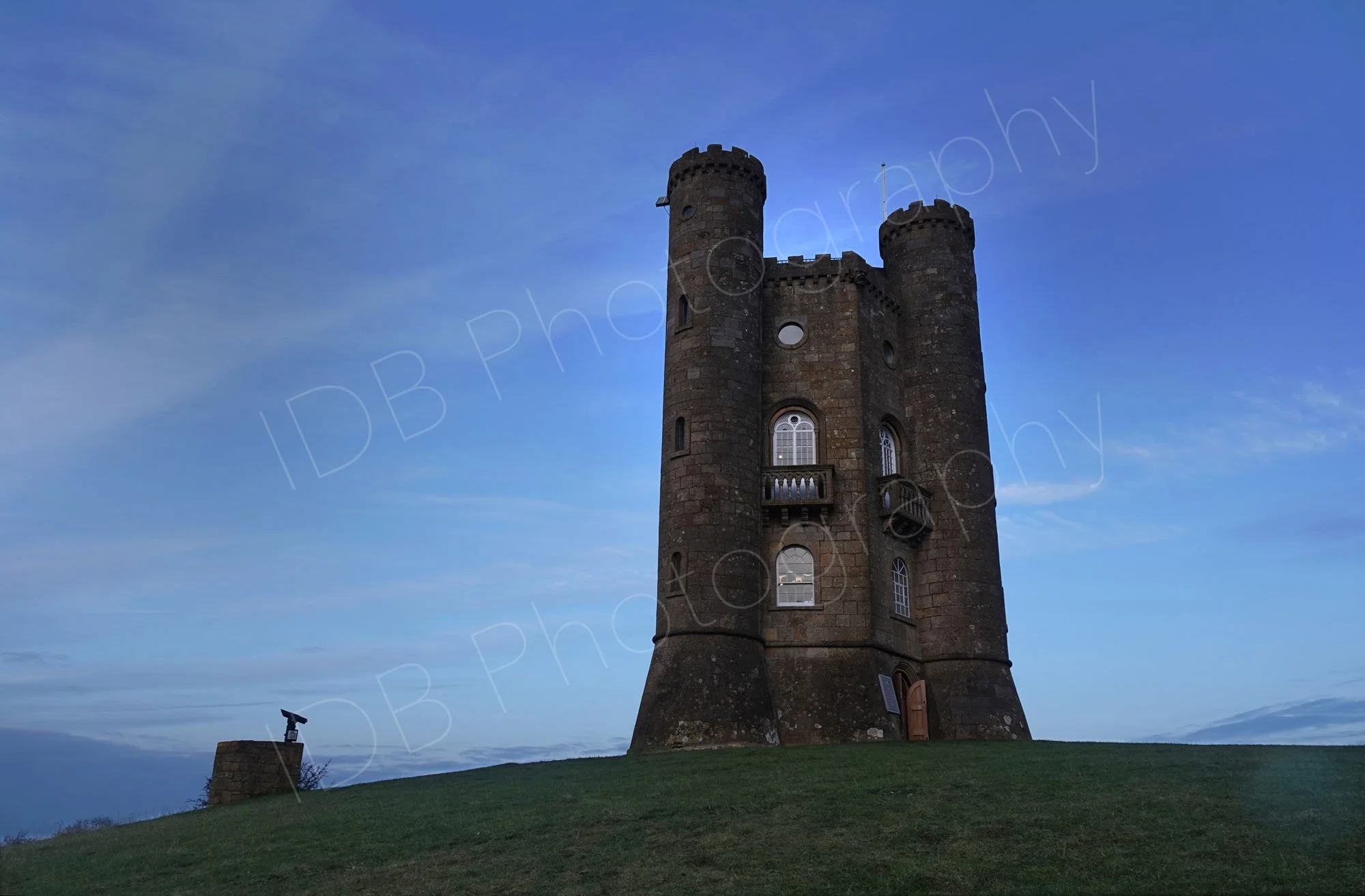 Broadway Tower, Worcestershire, in fading light  with streaky clouds in a dark blue sky.