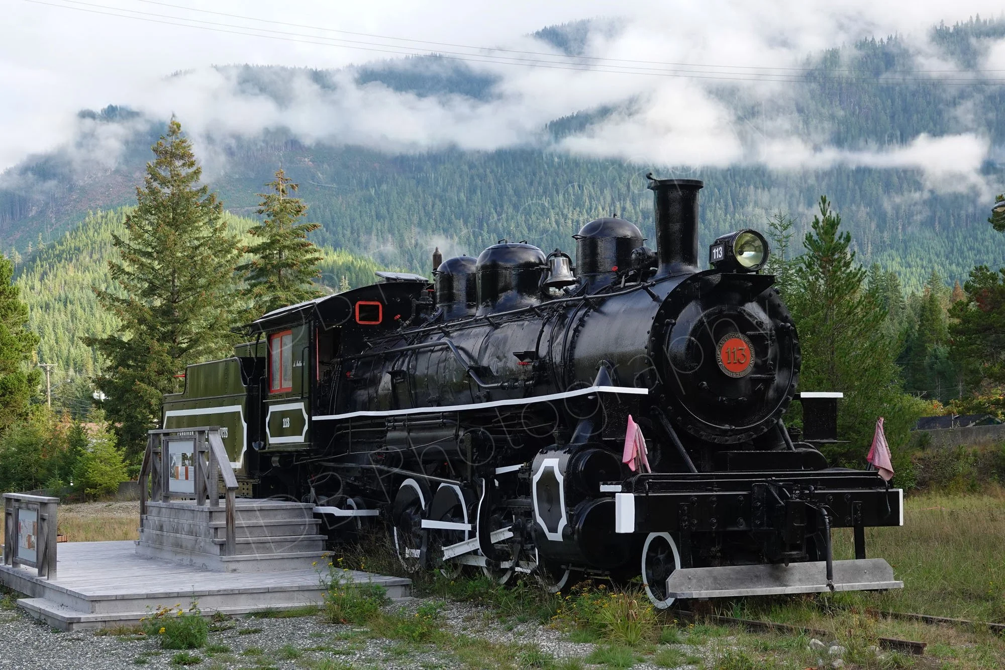 Steam Locomotive No. 113  with scenic background and clouds akin to steam at Woss Heritage Park, Vancouver Island, BC. Canada.