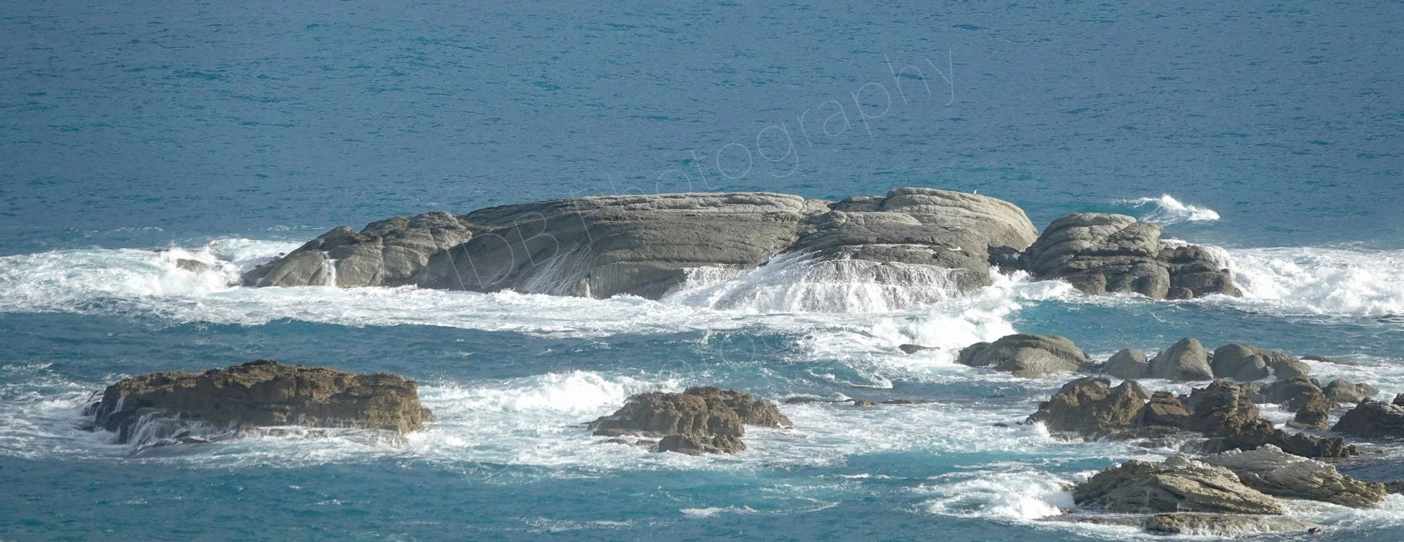 Panoramic type view of a group of rocks and cascading water at Kaikoura, Canterbury, New Zealand.