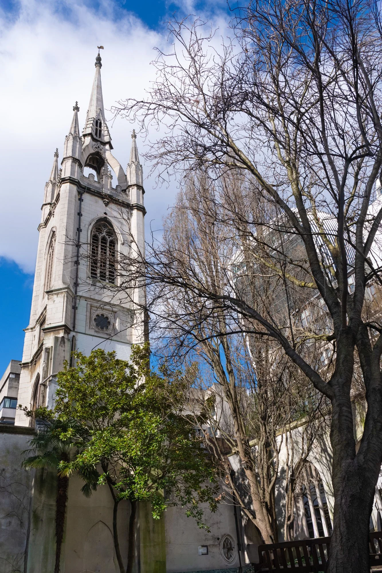 Sir Christopher Wren's tower of St Dunstan-in-the -East with the modern Fenchurch Building, the "Walkie-Talkie", seen through the bare tree branches.