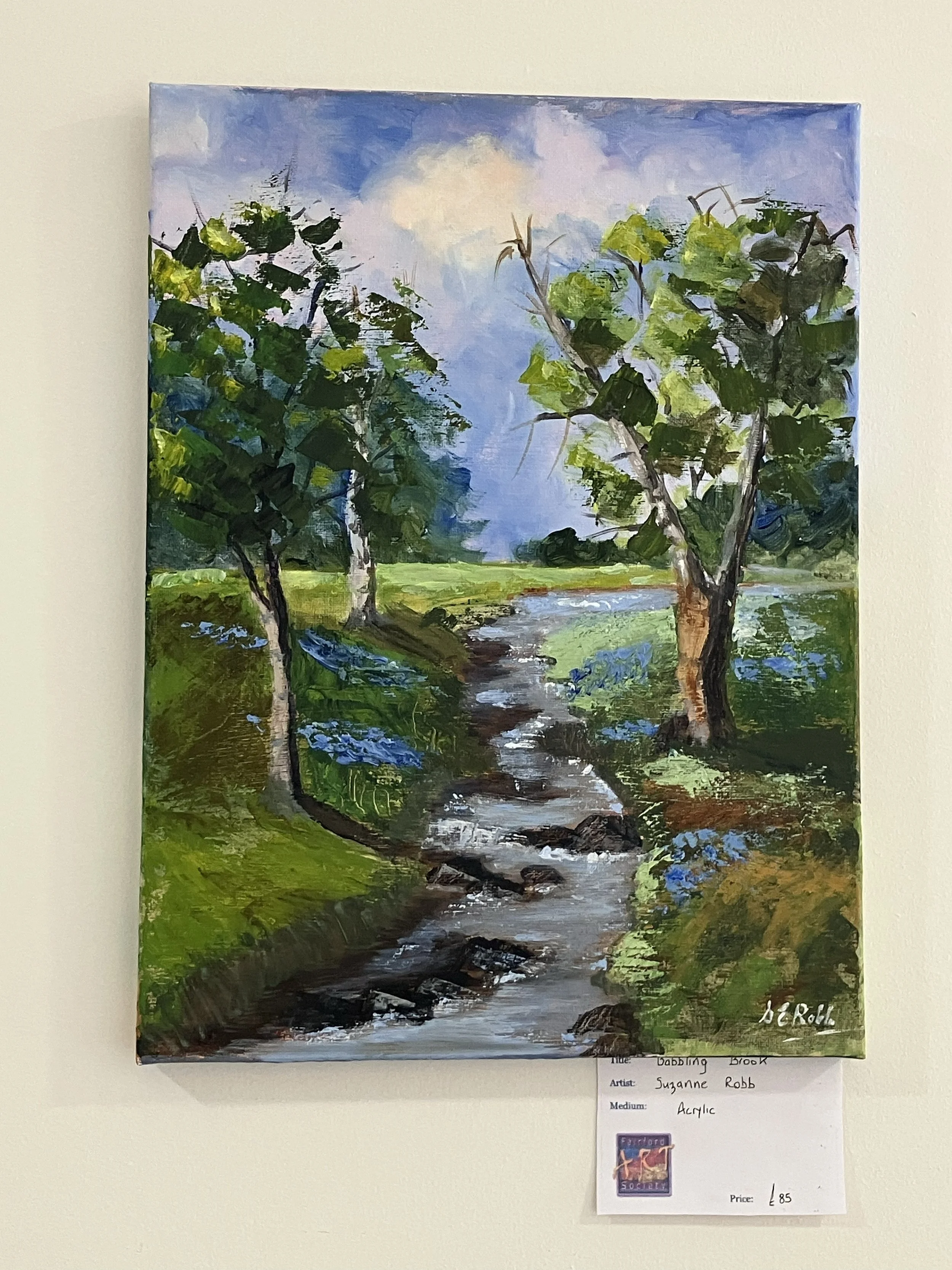 An painting of a nature scene with a stream running through green grass and trees under a partly cloudy sky.