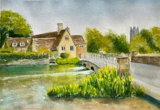 A watercolor painting of a quaint village scene with houses, a stone bridge over a creek, greenery, and a distant church tower.