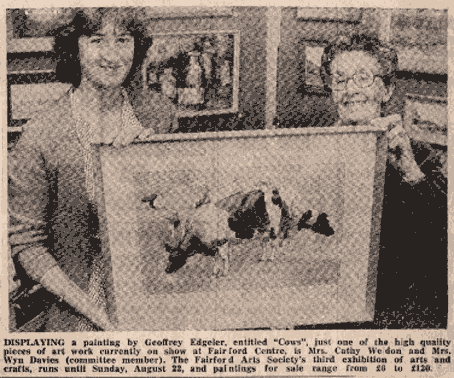 Two women standing inside a store, holding a framed painting of cows, with shelves and other artworks in the background.