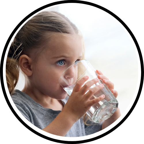 Young girl with blue eyes drinking water from a glass