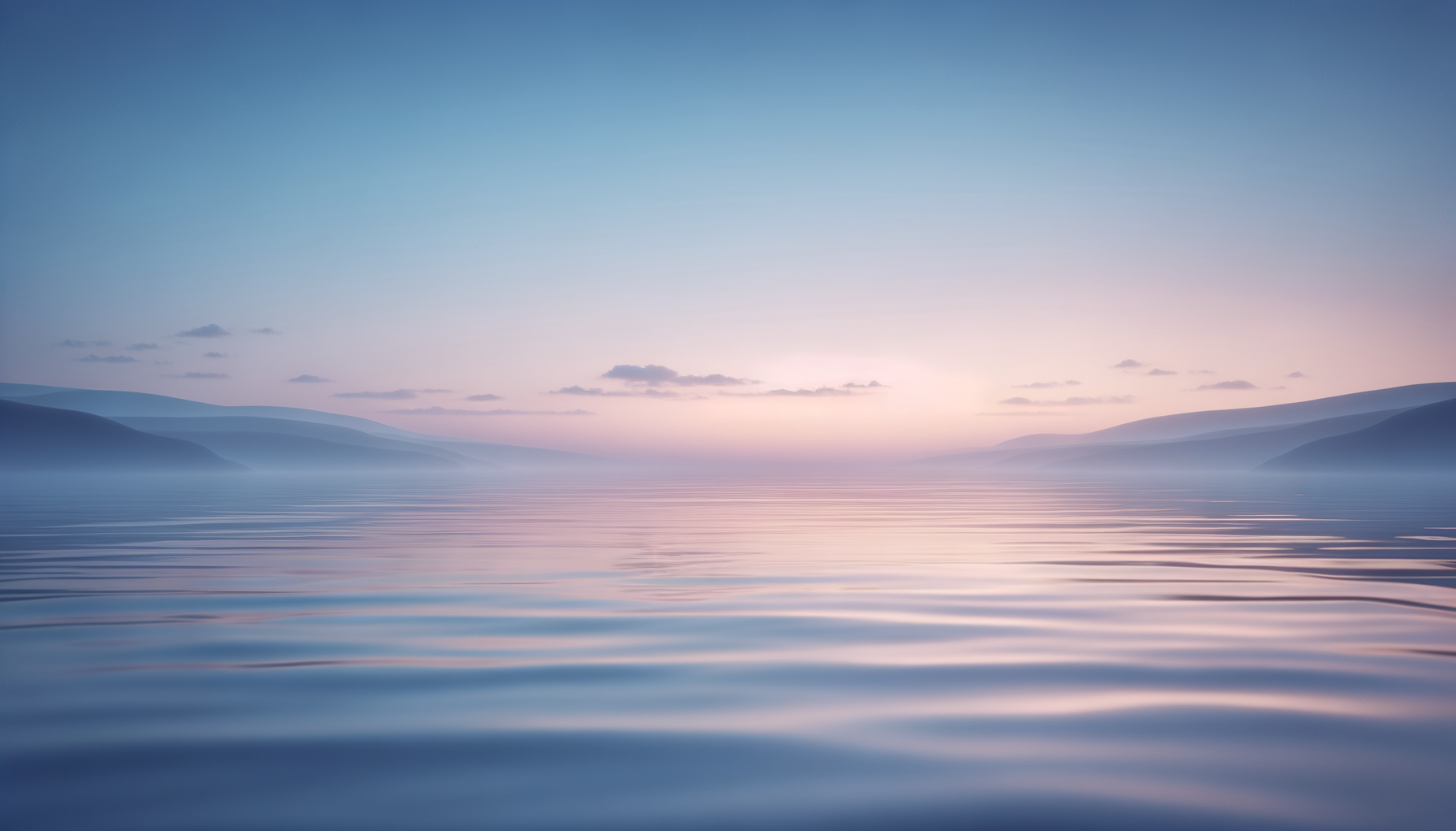 Calm lake with gentle ripples reflecting a pastel-colored sky at sunset, surrounded by distant mountains.