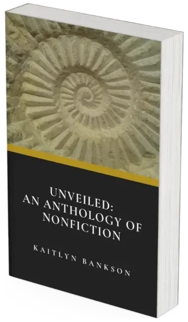 3D mockup of the paperback anthology Unveiled: An Anthology of Nonfiction by Kaitlyn Bankson, featuring a fossilized spiral ammonite shell embossed in stone on the book cover.