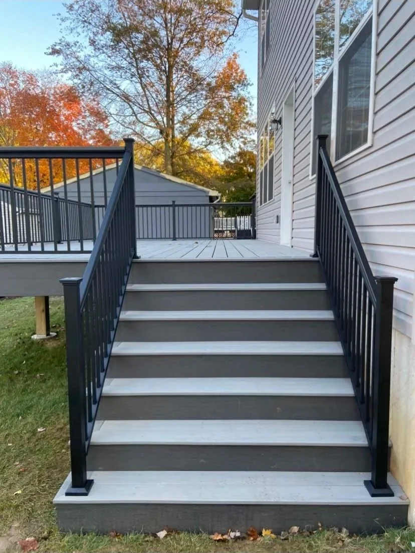 After - TimberTech Composite decking with complementary fascia on rim and beam with black aluminum 2.5'' handrail system with solar light caps