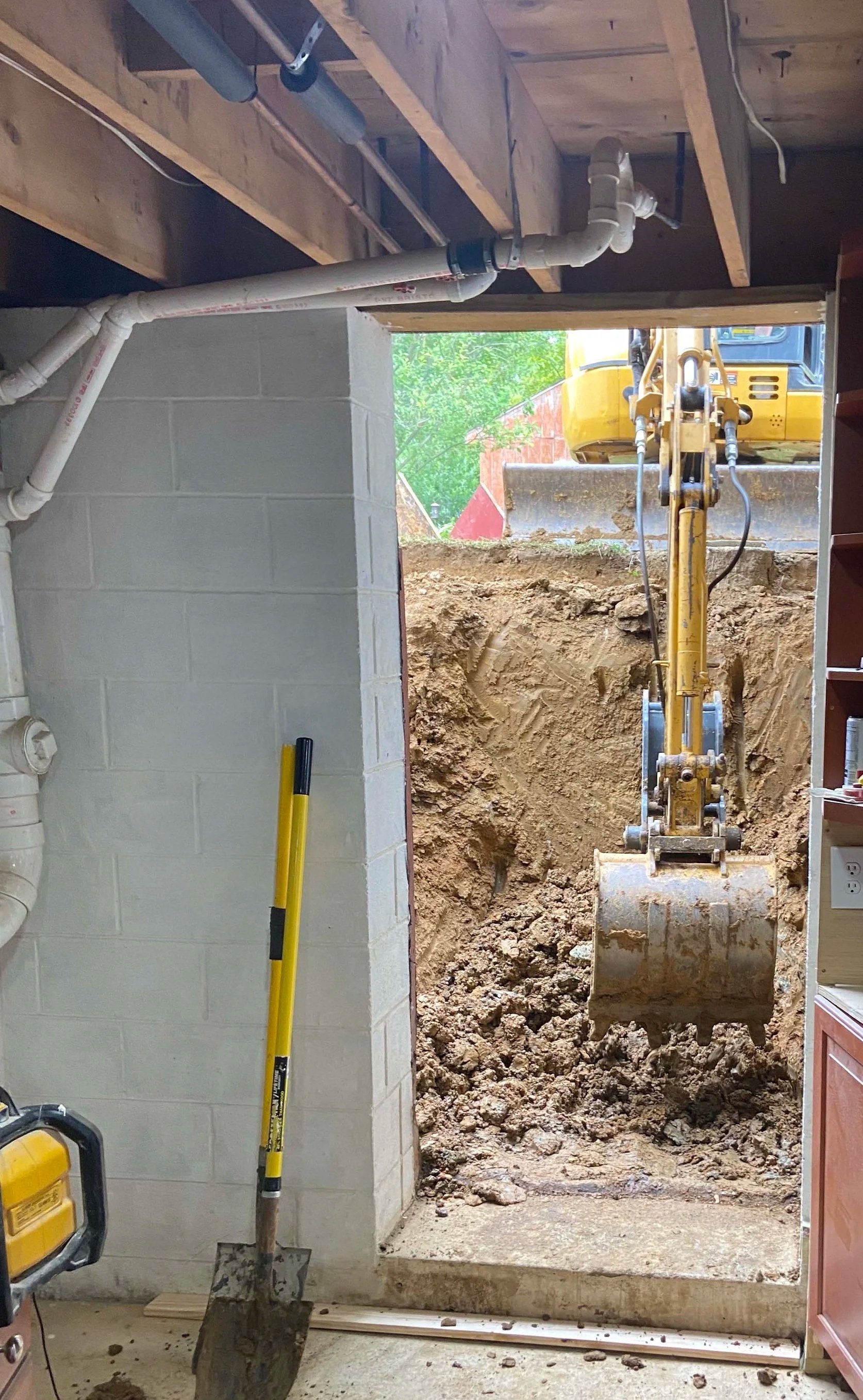 During - Licensed operator moving heavy clay and dirt to allow for drainage pipe to be laid for improved drainage