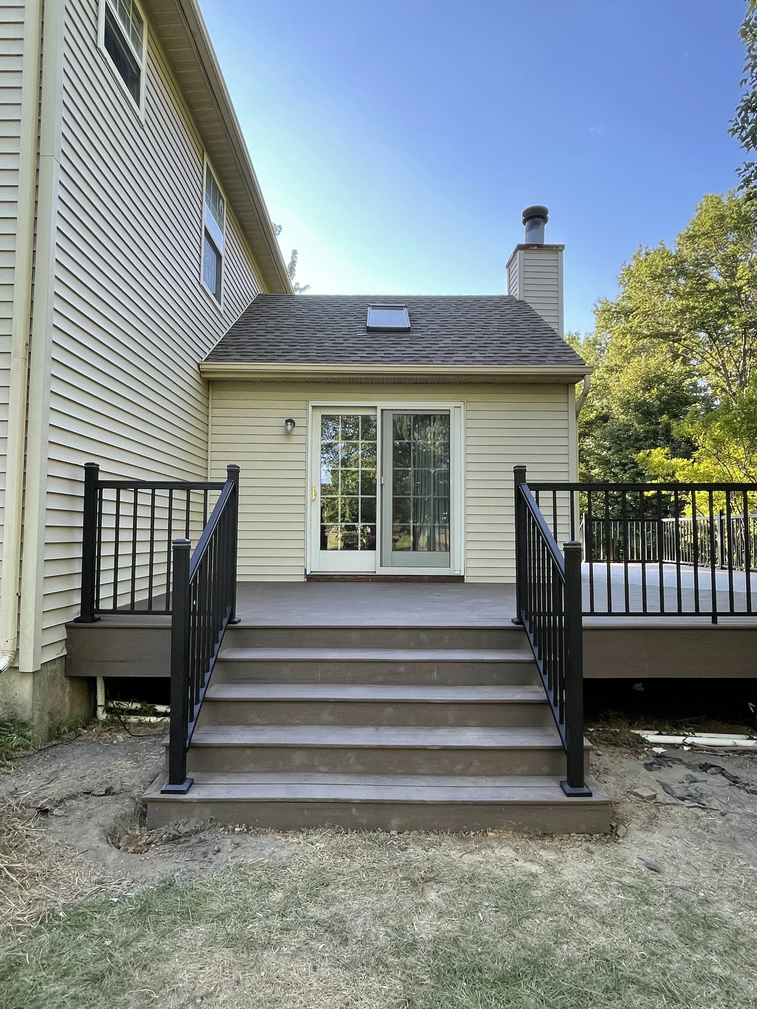 After - TimberTech Composite Deck - Widened stair access with 2.5'' black aluminum railing with wired light caps