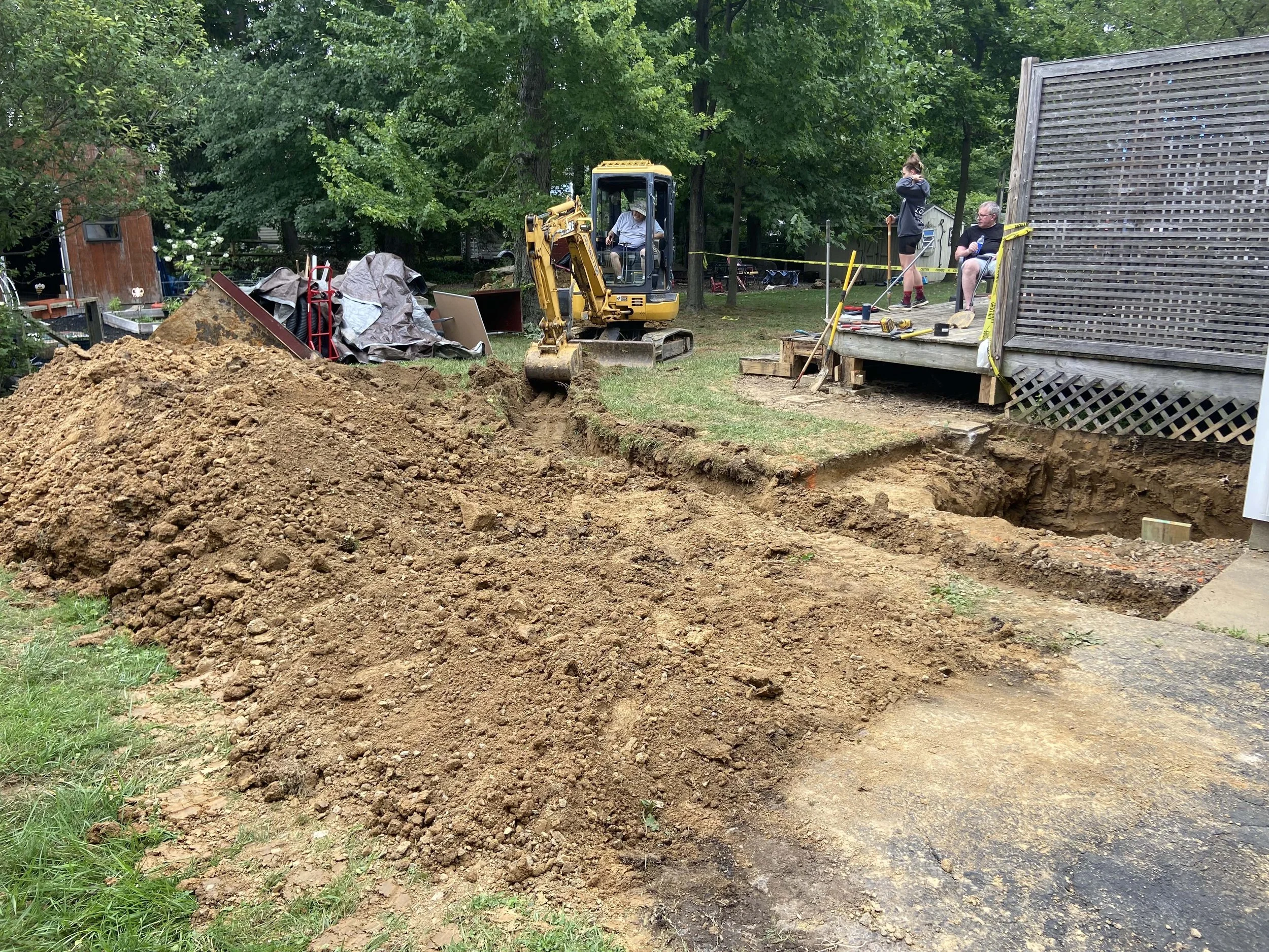 During - Licensed operator moving heavy clay and dirt to allow for drainage pipe to be laid for improved drainage