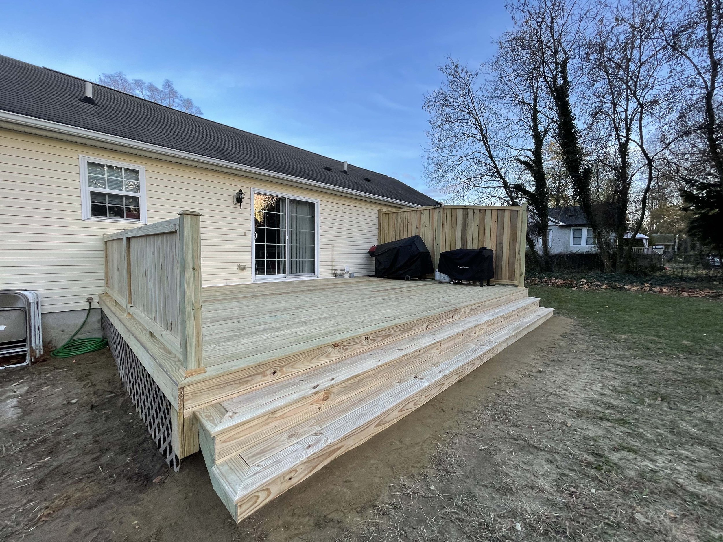 After - New pressure treated deck, waterfall stairs and hand crafted privacy fence and railing
