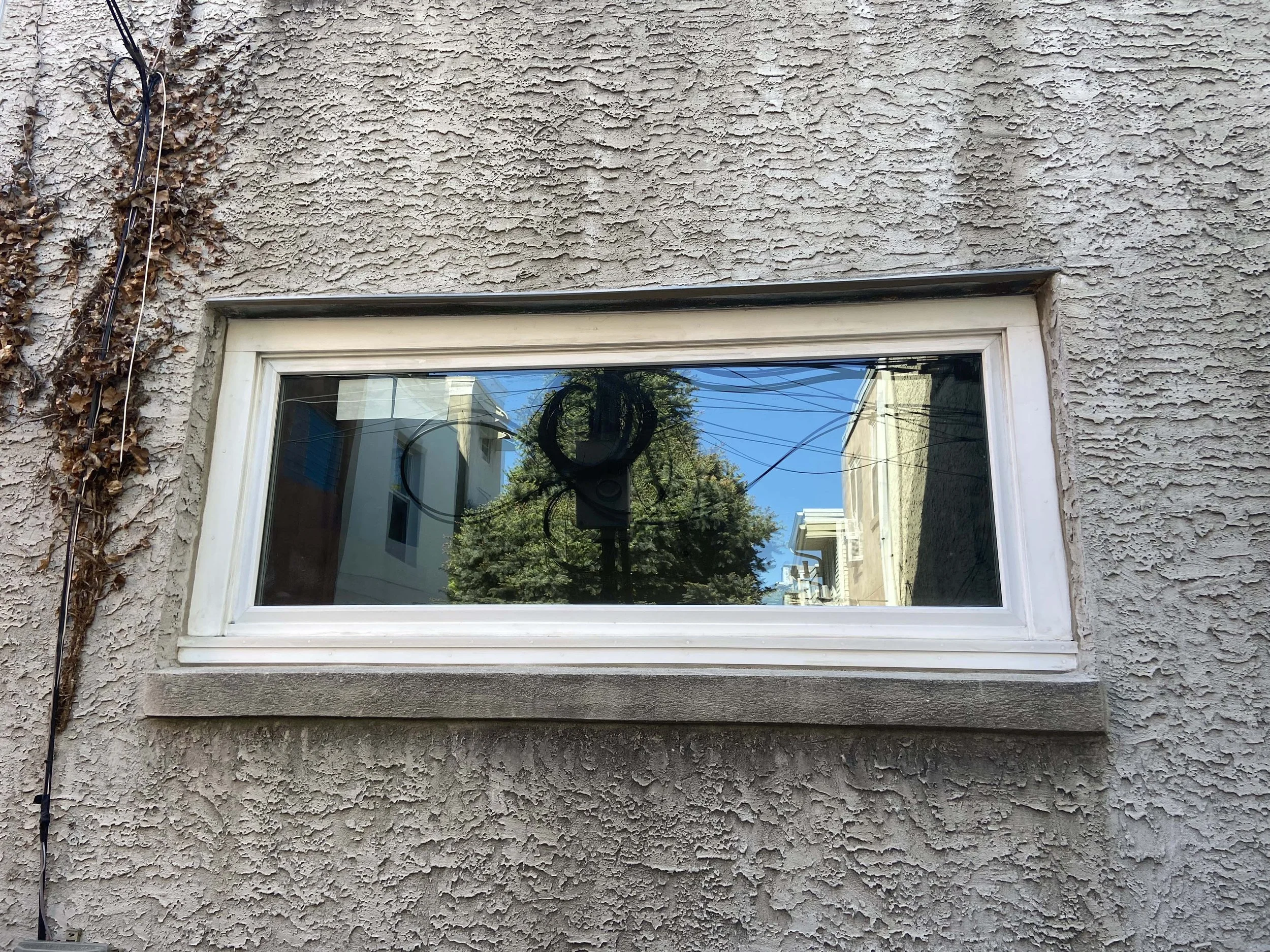 After - Custom sized fixed window with custom trim to match this early 1900s home and set seamlessly into existing masonry