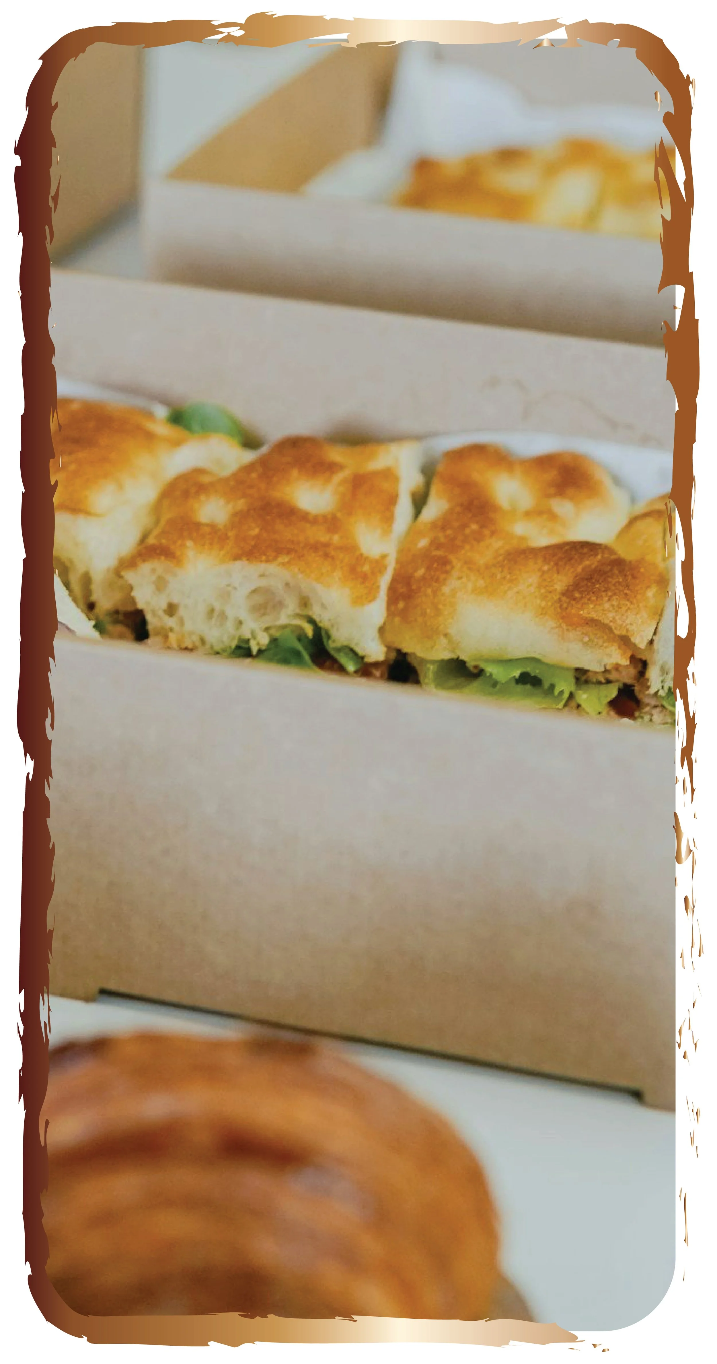 Close-up of a sandwich with toasted bread, lettuce, and possibly other ingredients inside a white takeout box.
