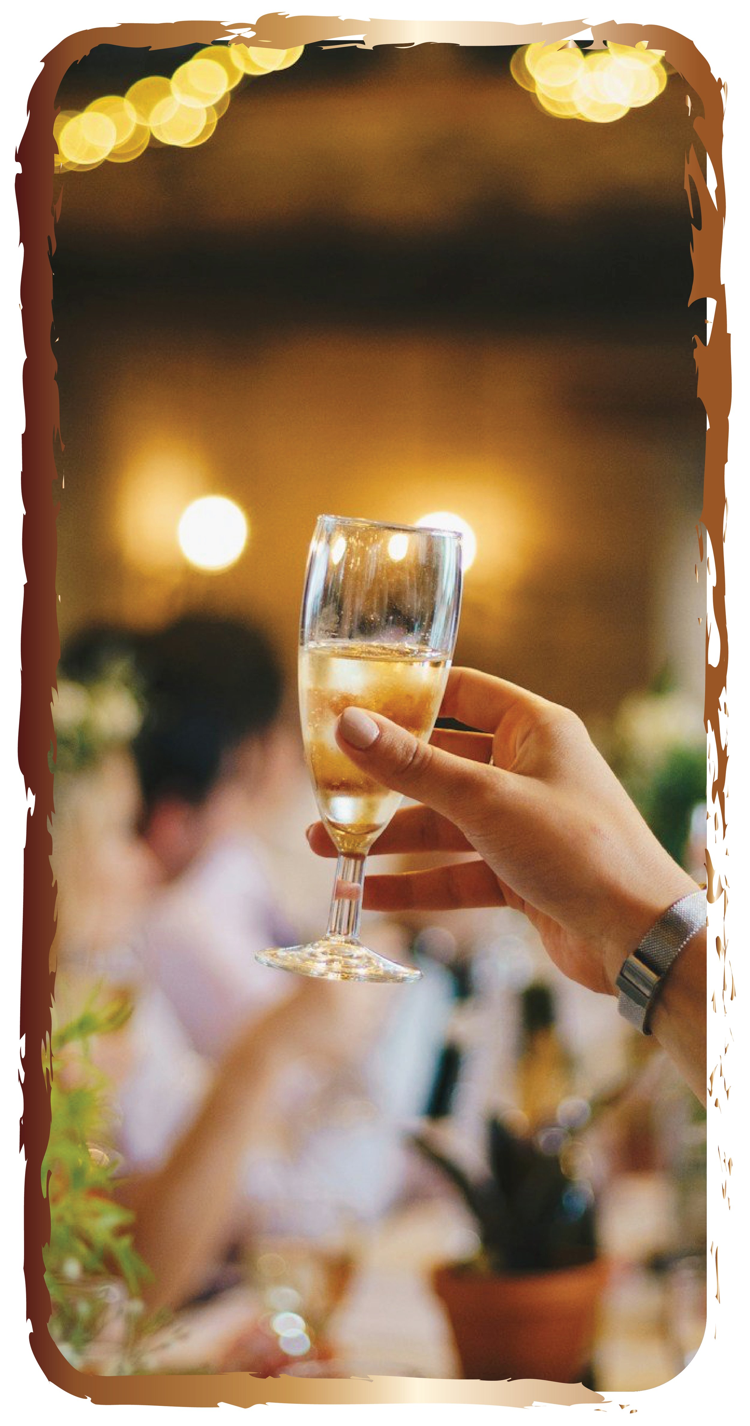 Person holding a glass of champagne at a celebration or gathering with blurred background and warm lighting.