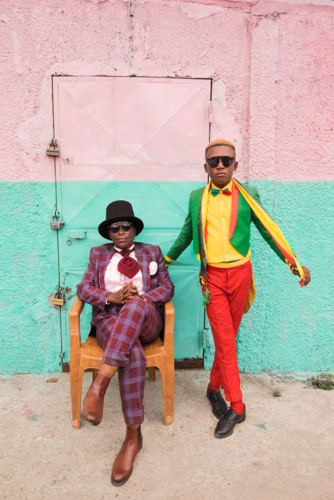 Scenic landscape of a mountain range with grassy hills in the foreground and a clear sky overhead.