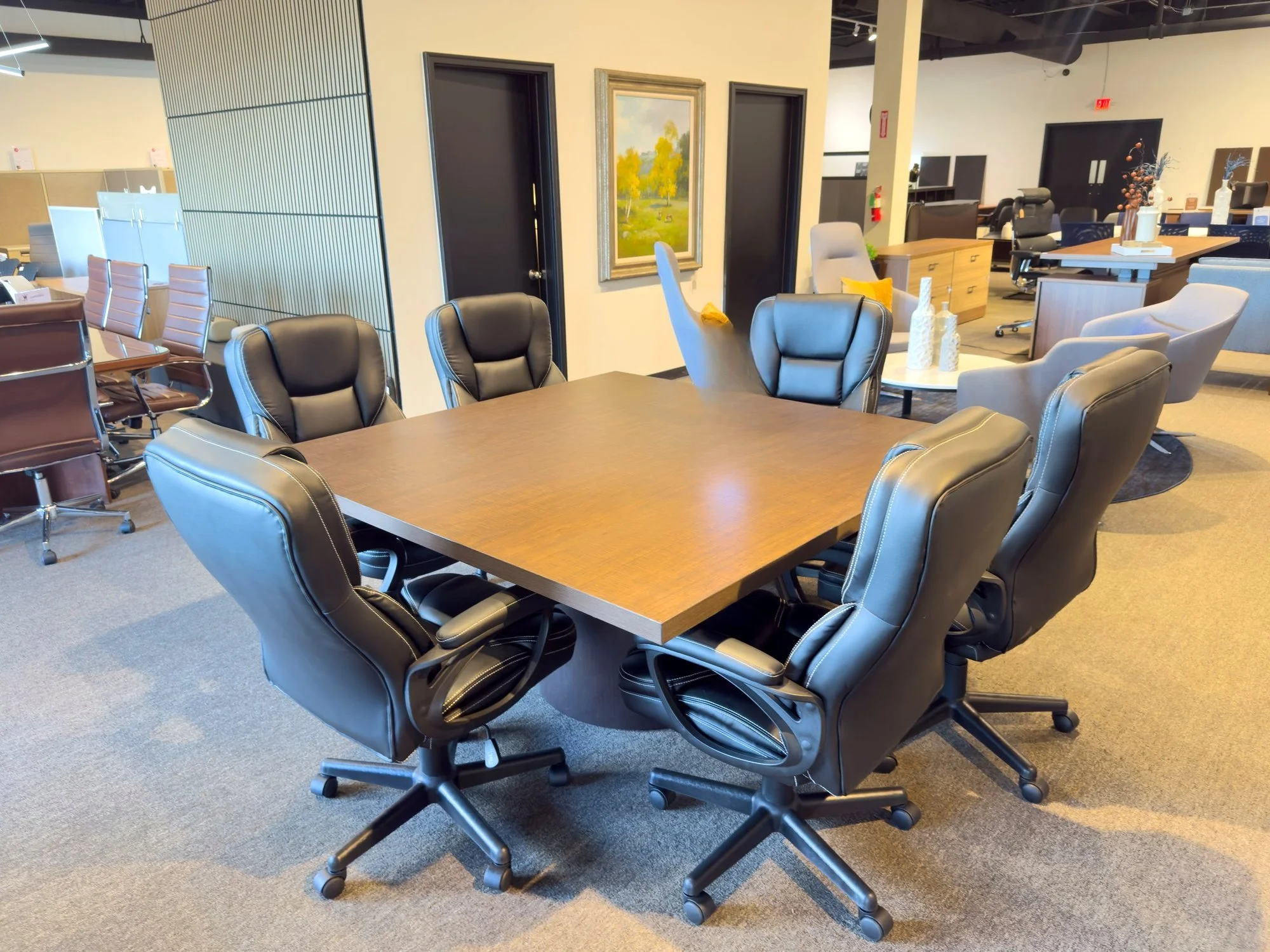 7PC Conference Package — showroom view of conference table and black leather chairs